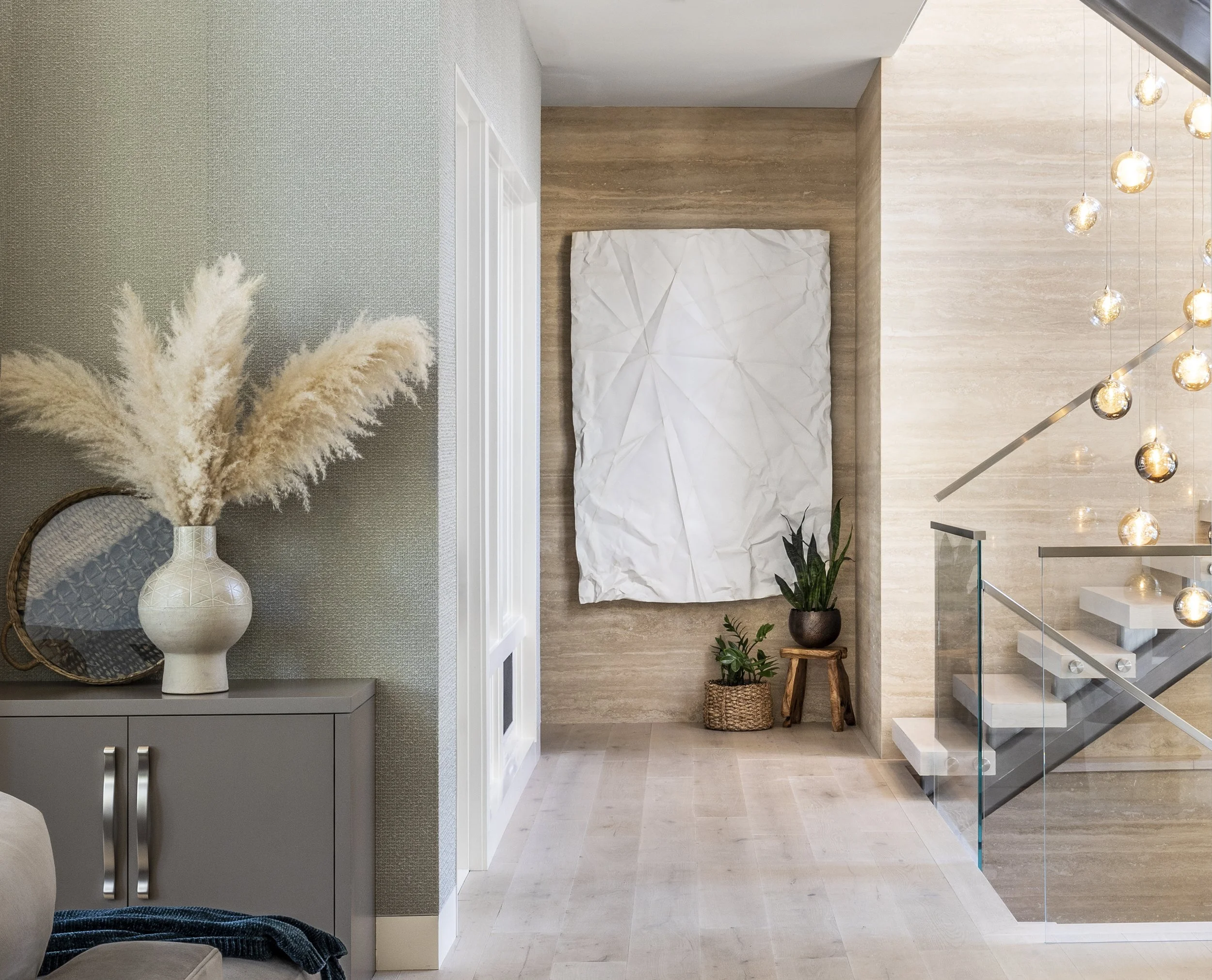 Mountain modern stair with floating treads, glass railings, cedar T&G ceiling, and a custom stunning glass chandelier that cascades down the main level in Martis Camp Truckee CA. Stone walls and custom oak wood floors. Textured wallpaper on the walls