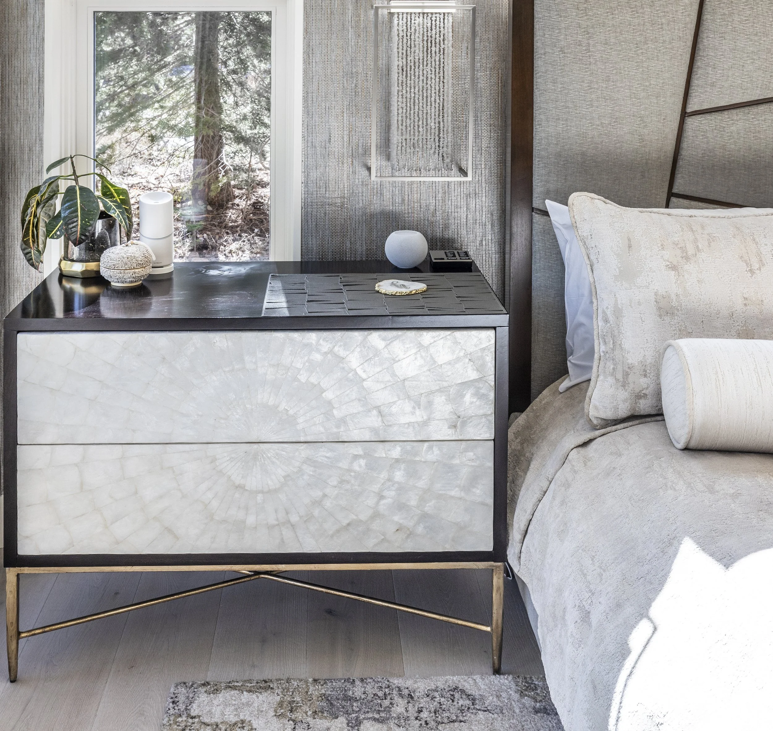 Primary mountain modern bedroom created to be luxurious with warm woods, cream, gold, and tan accents with the walls dressed in two different wallpapers. The window shades are recessed for a more modern and sleek design. Custom wood floors and ample 