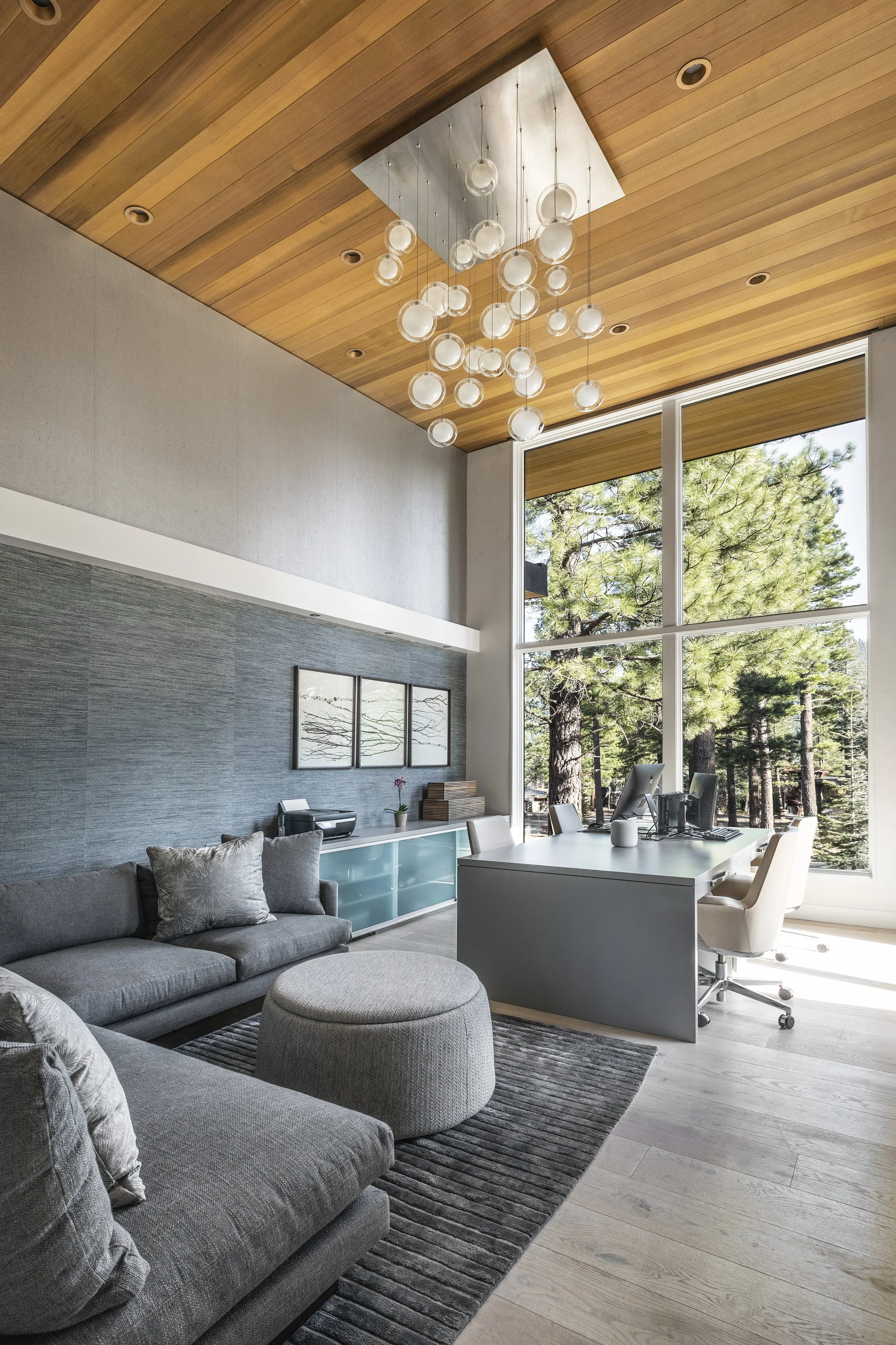 Mountain modern bright media and family room with a custom 4 person desk and walls covered in two textured and natural wallpapers in Martis Camp in Truckee, CA.