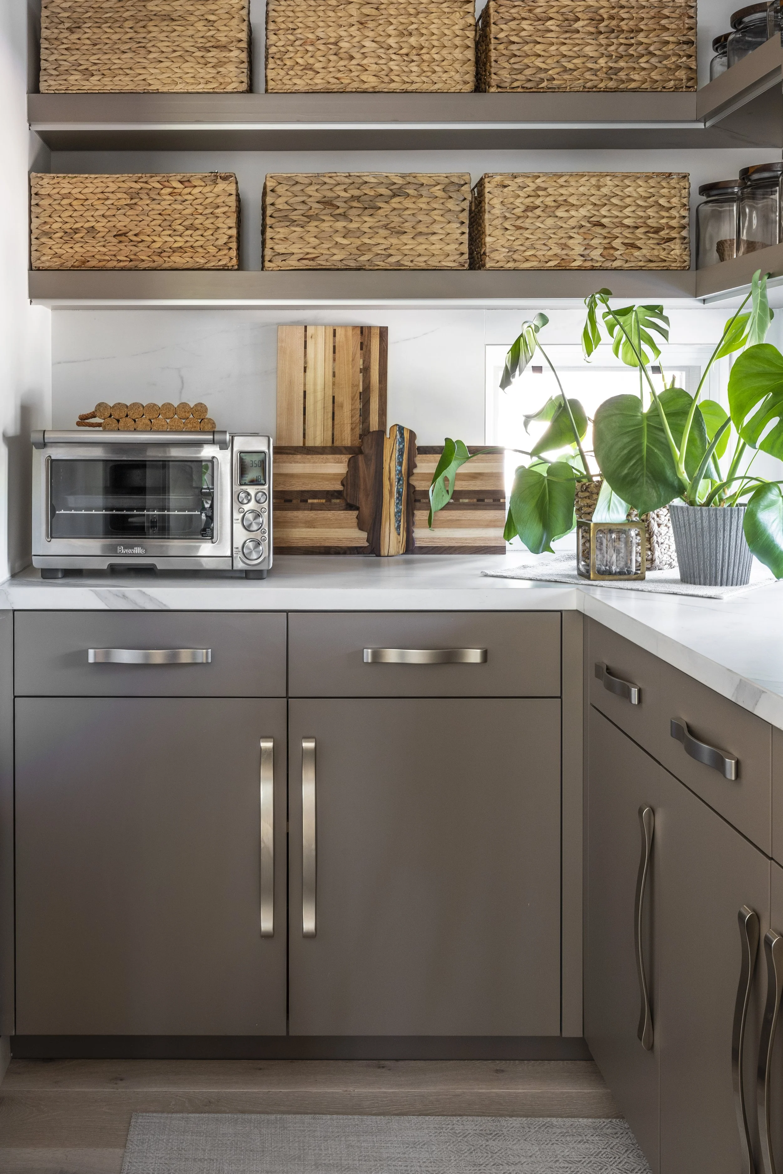Mountain modern pantry with porcelain countertop and backsplash in Martis Camp Truckee CA. Features a beverage fridge and ice maker with ample storage and undershelf lighting to properly light the space.