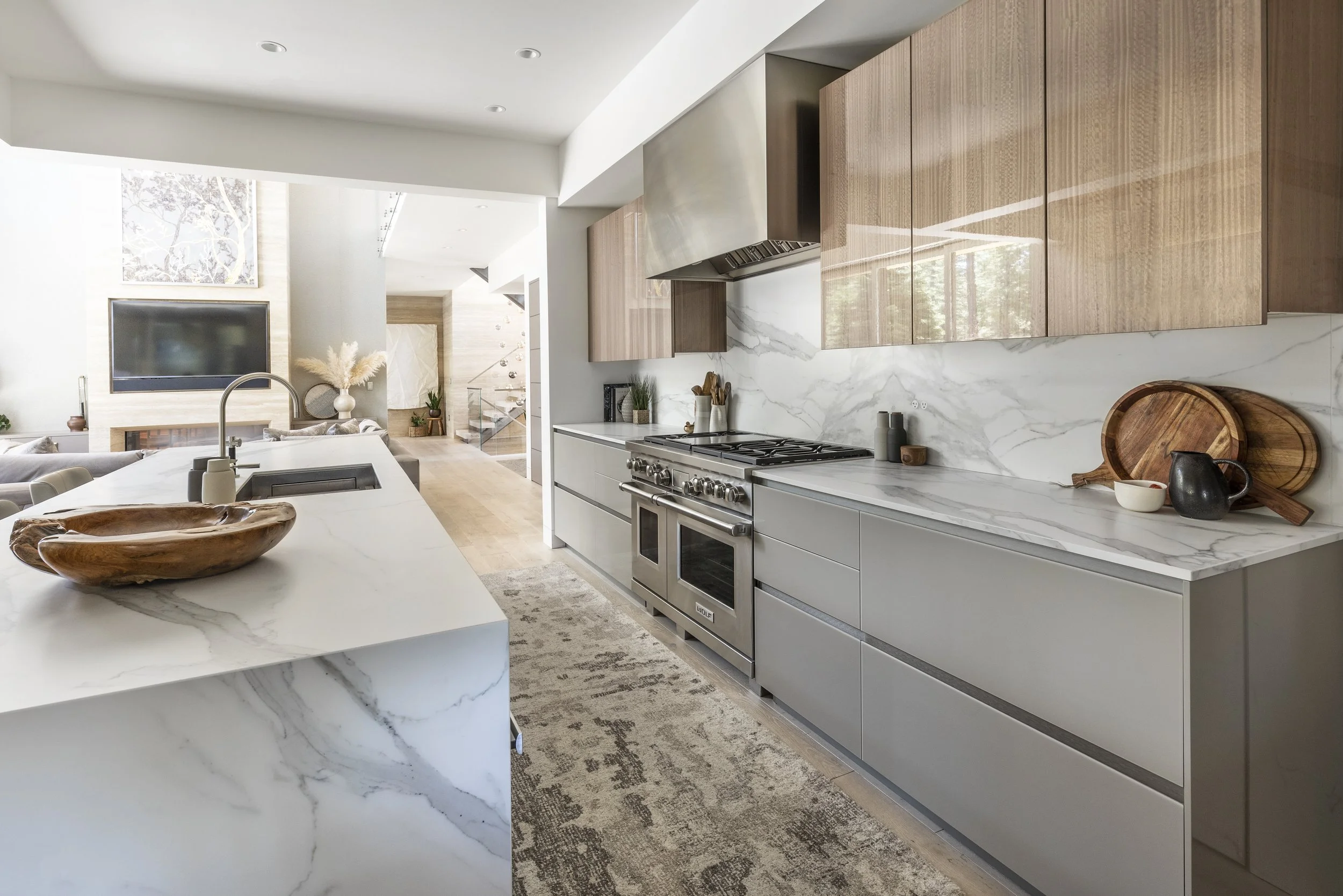 Mountain modern kitchen with porcelain countertops and backsplash in Martis Camp Truckee CA. Cabinets are a taupe glass and resin coated eucalyptus.