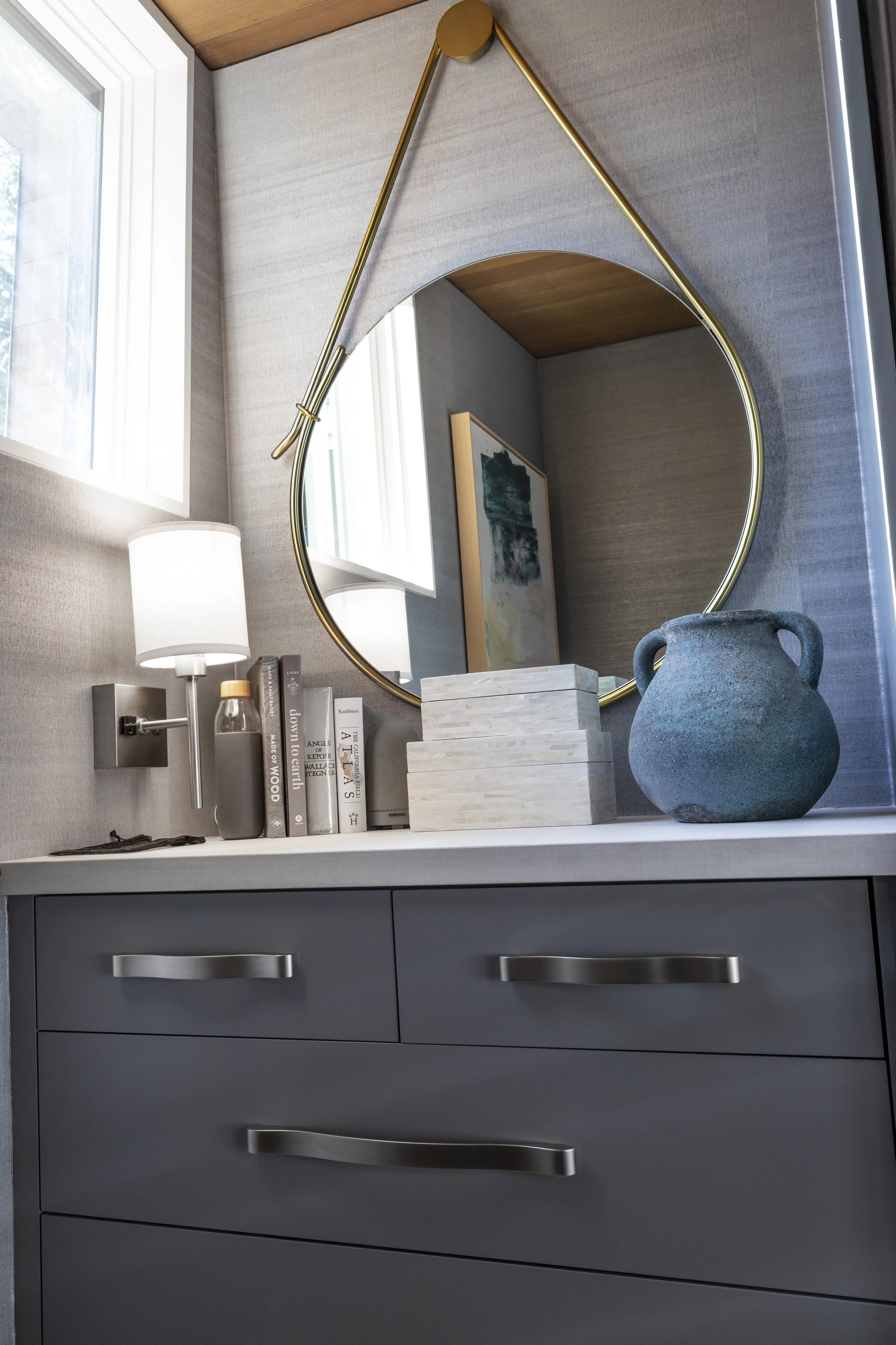 Custom closet for her complete with wallpaper on the walls, wall sconces, a decorative mirror and ample organized storage.