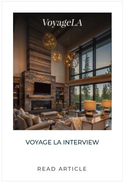 Interior of a modern living room with large windows, a stone fireplace, contemporary furniture, and hanging pendant lights.