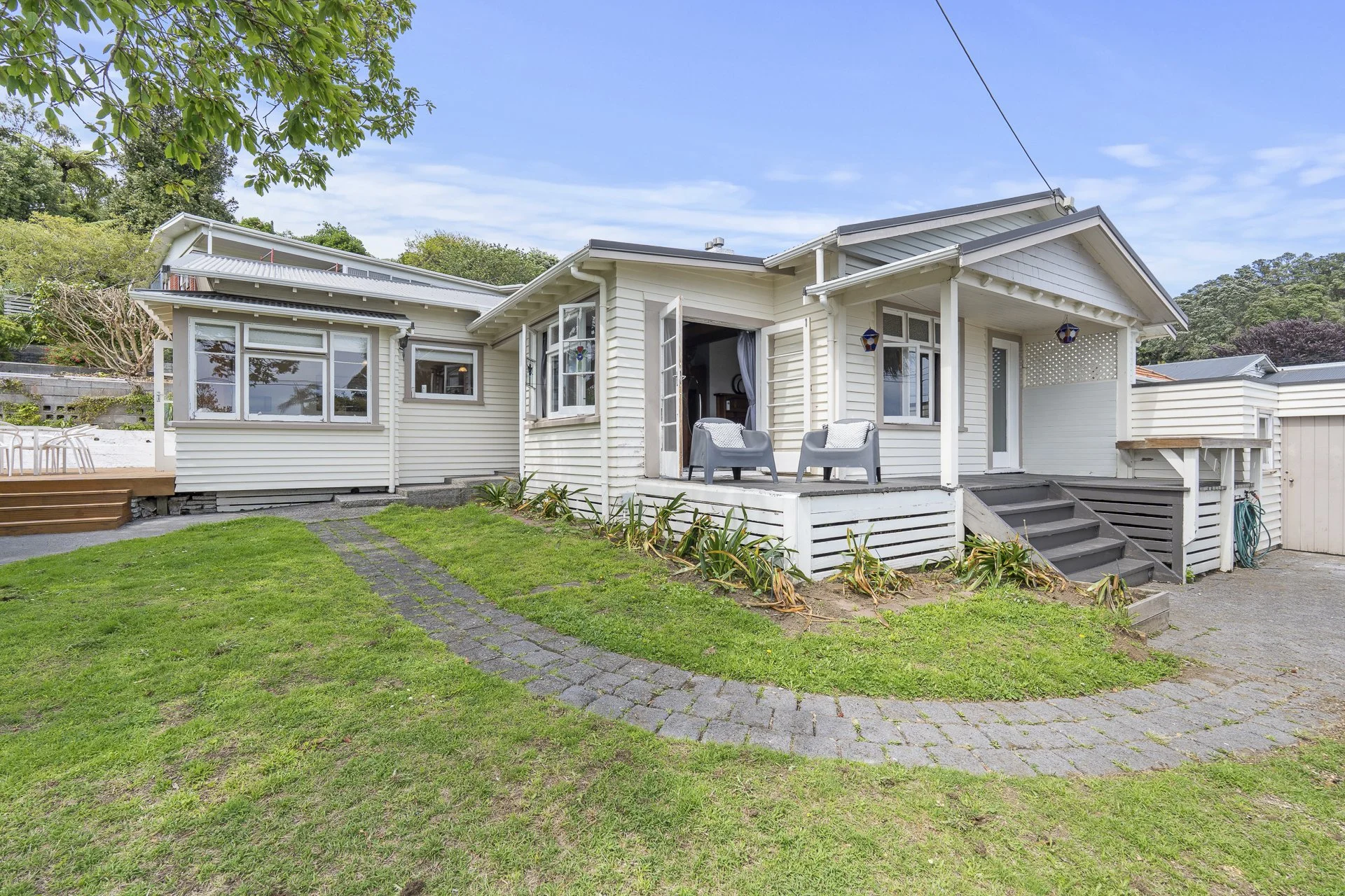 95 Fulford Street, New Plymouth City Central.  A character bungalow with a raised porch, multiple windows, and a backyard with a grassy lawn and a stone pathway.