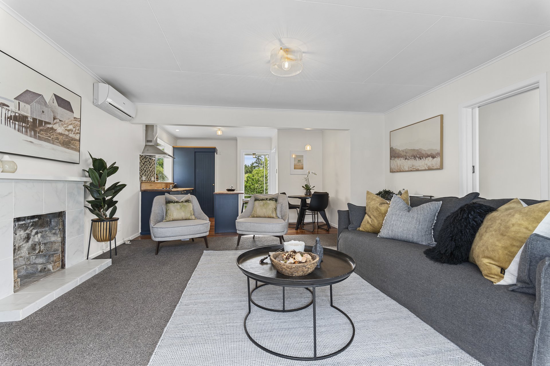22 Bulteel Street, New Plymouth central.  With a living room, luxury decor, built-in fireplace, and a view of a green outdoor landscape through the windows.