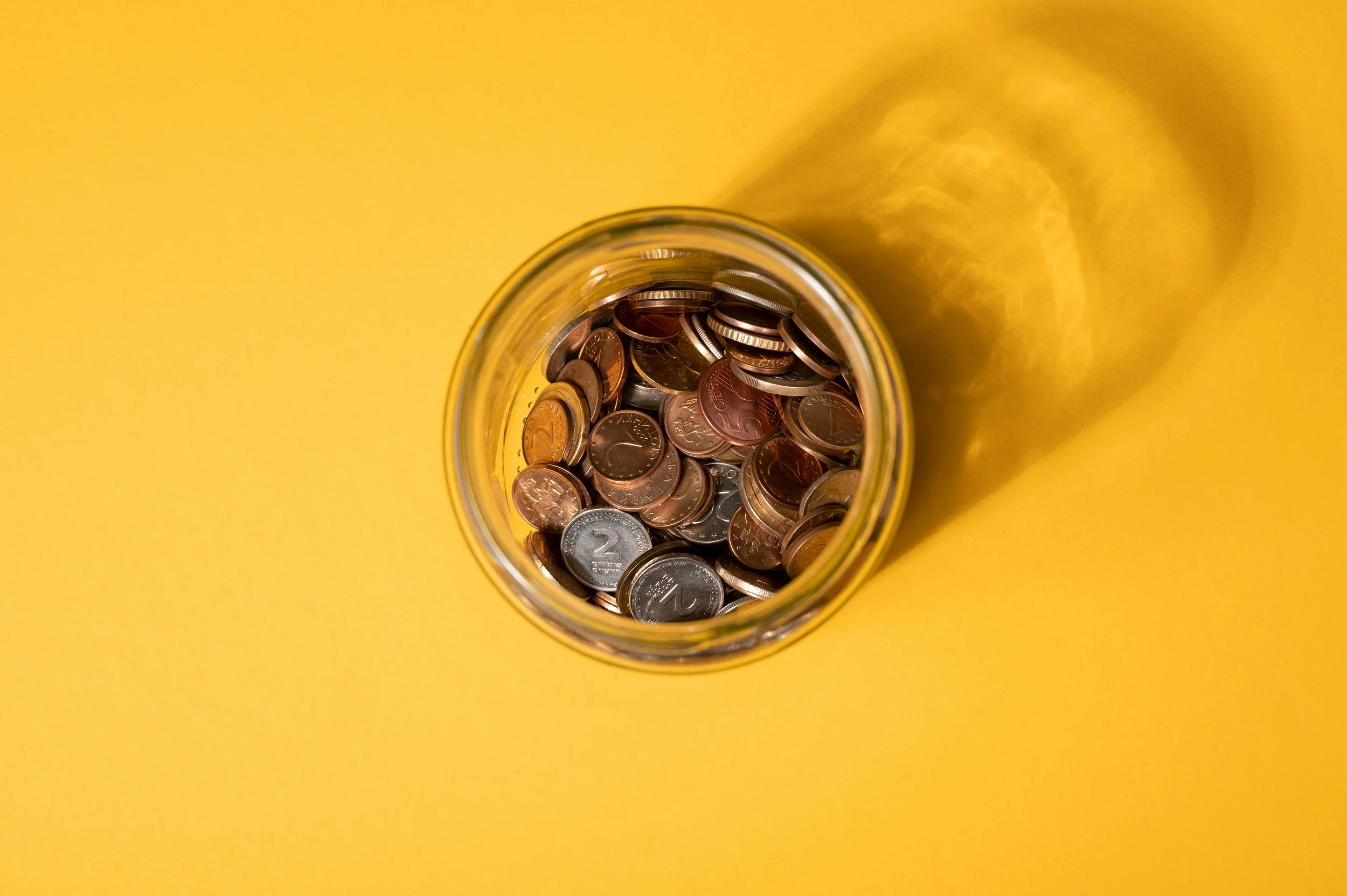 A jar of coins over a yellow background