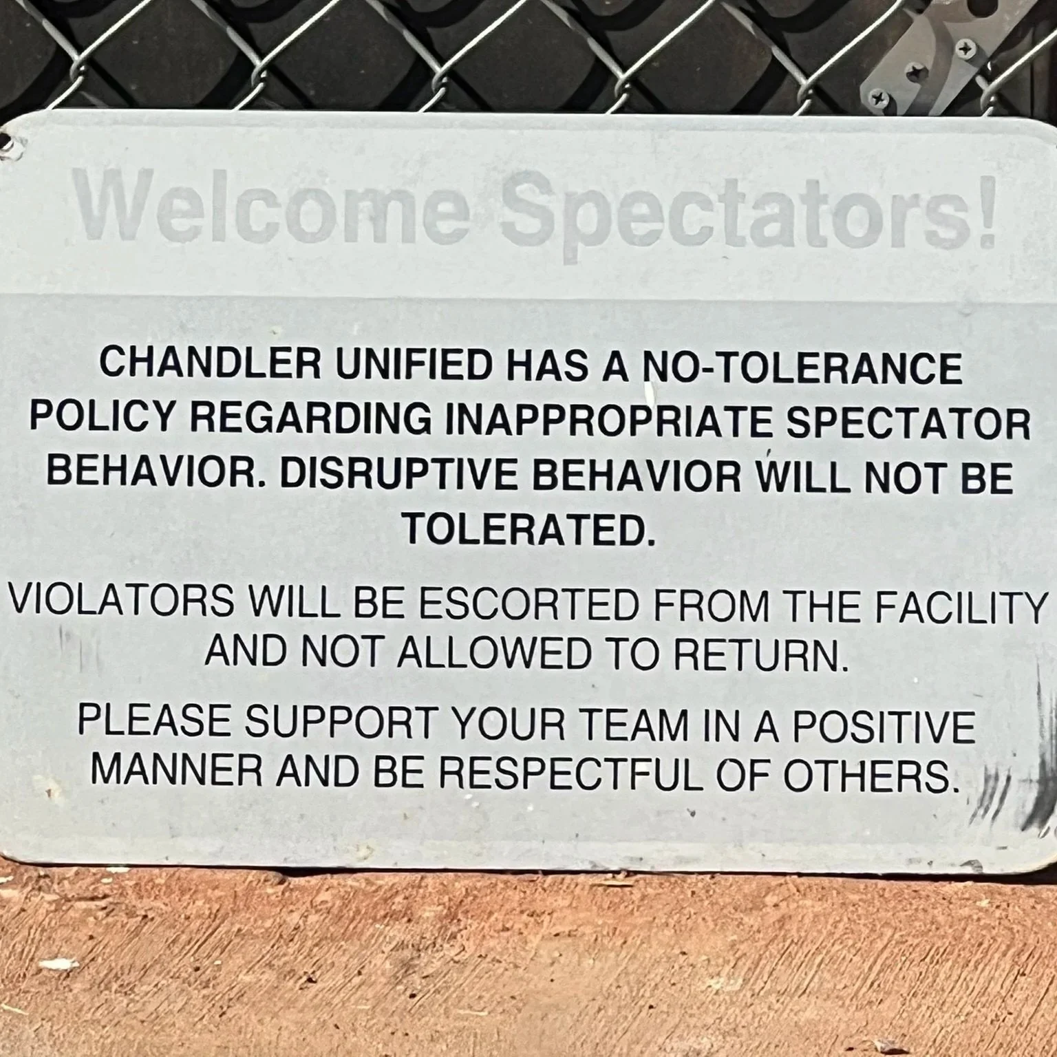 A posted sign outlines spectator behavior rules, emphasizing respect and warning against disruptive conduct at the facility.