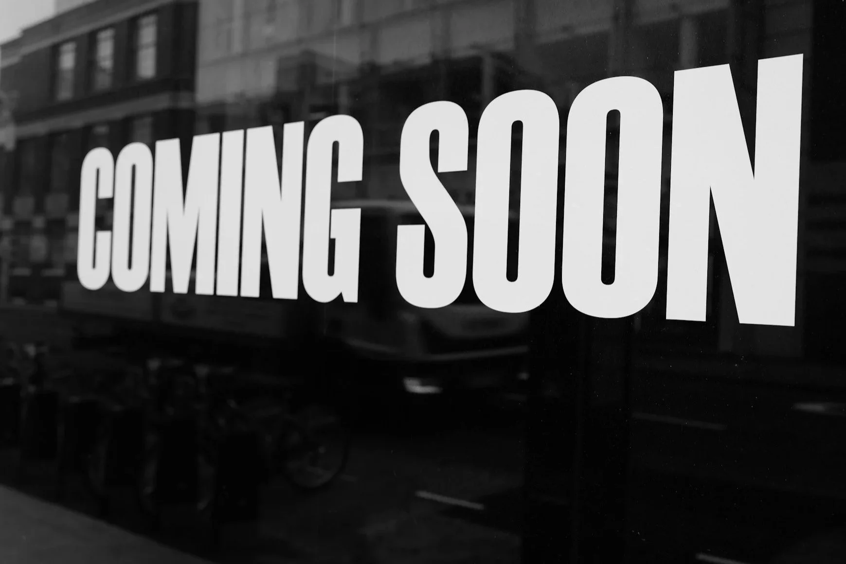 A window with a sign that reads 'COMING SOON' in large white letters.
