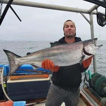 Man holding a large fish on a boat