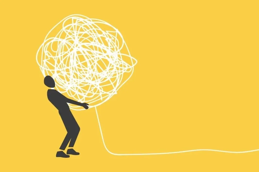 Silhouette of a man holding a giant ball of string.