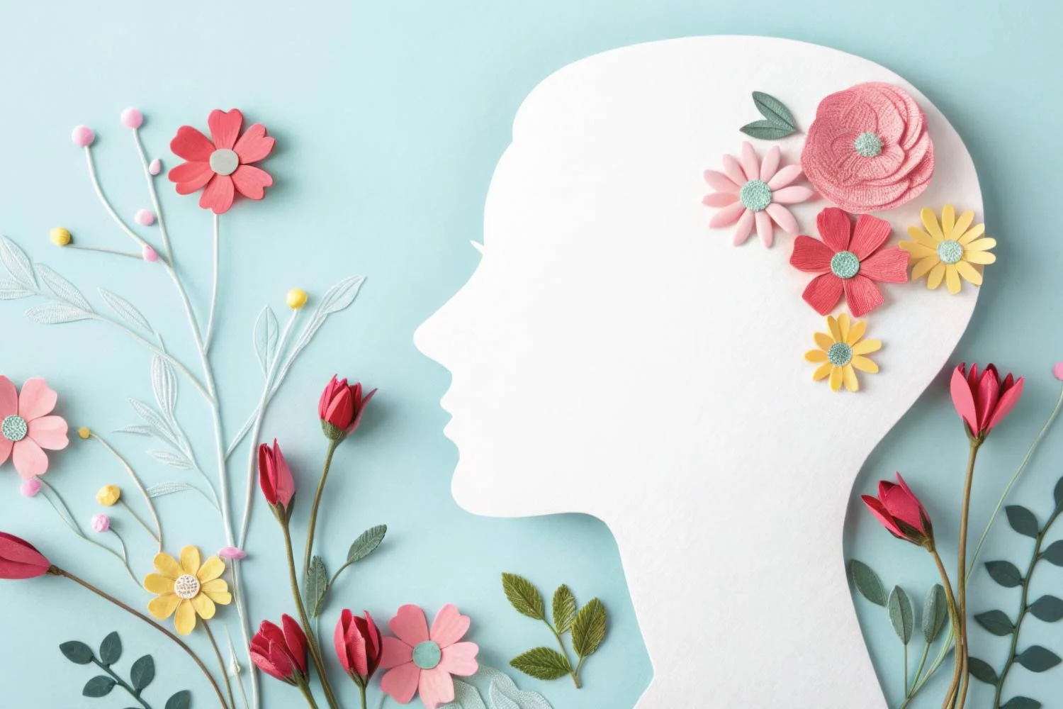 Paper-cut silhouette of a woman’s head surrounded by colorful flowers.