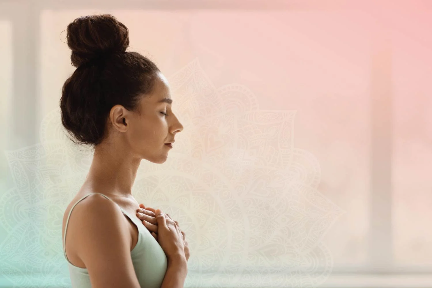 Woman meditating with her eyes closed and hands over her heart.