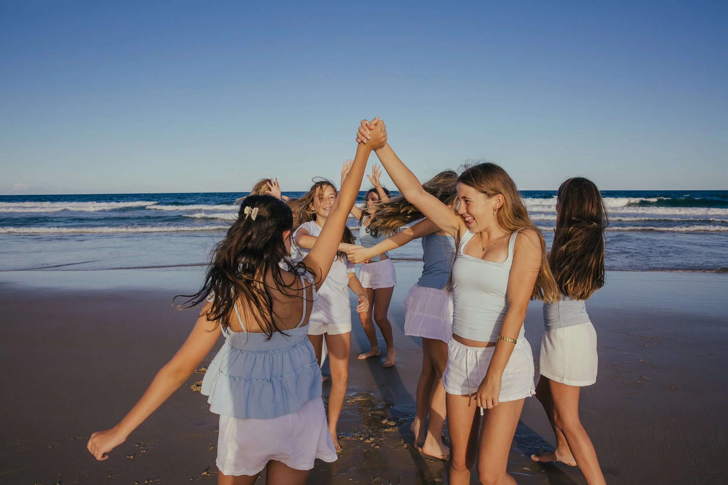 Group of women and girls dancing and having fun on a beach
