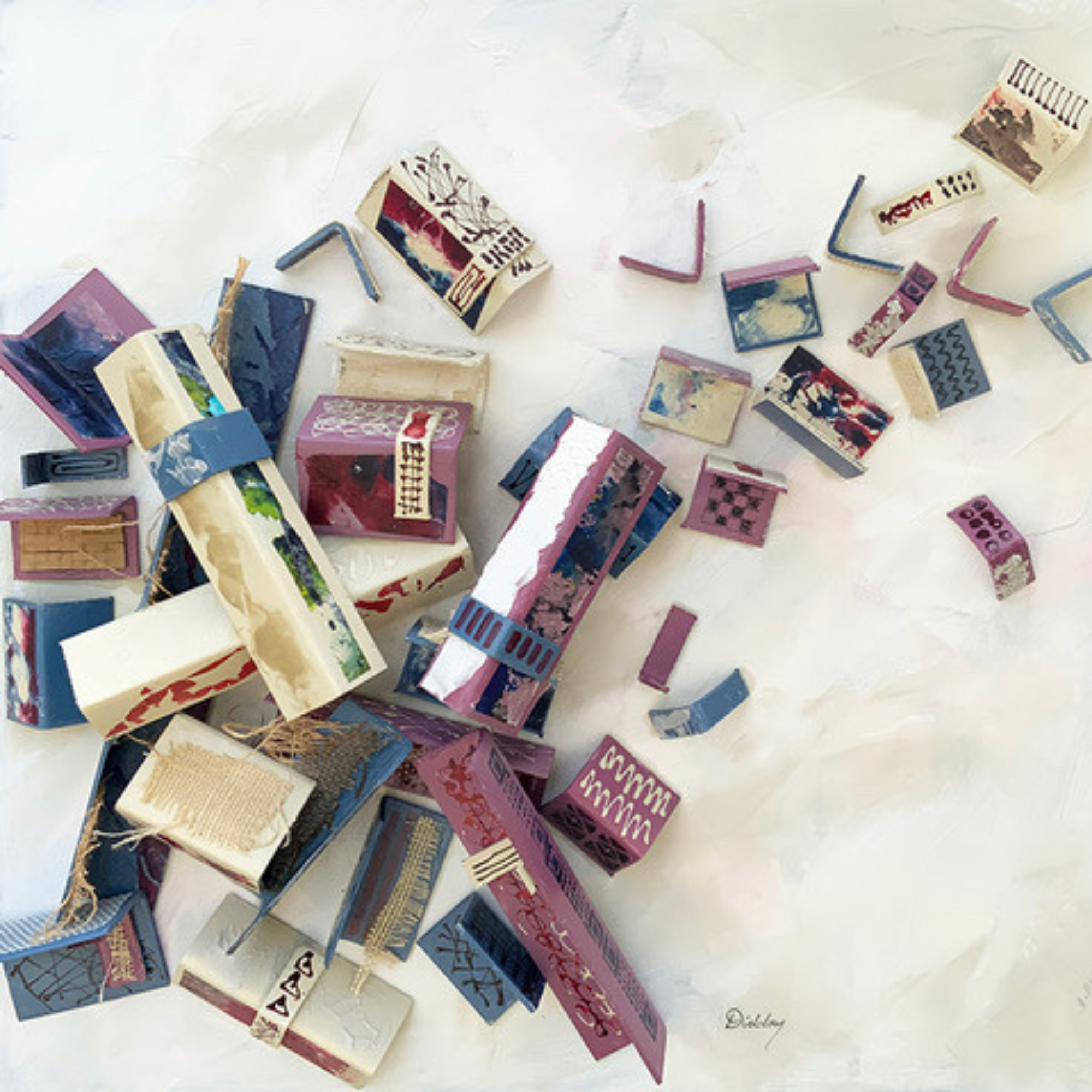 Colorful miniature cardboard houses scattered on a white surface.