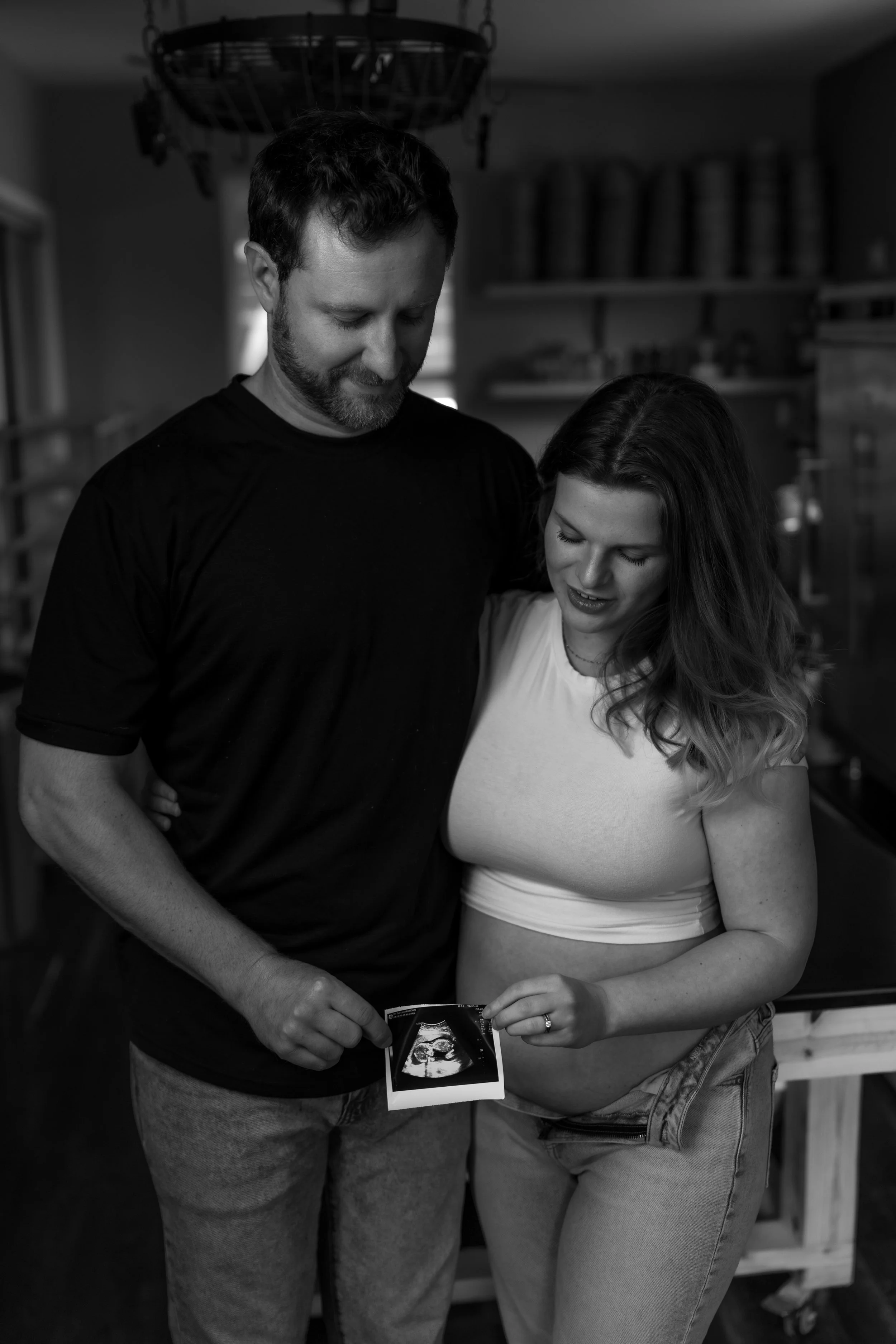 Pregnancy annoucment photo in black & white taken in their family bakery. Photo taken by and Austin Texas Photographer.
