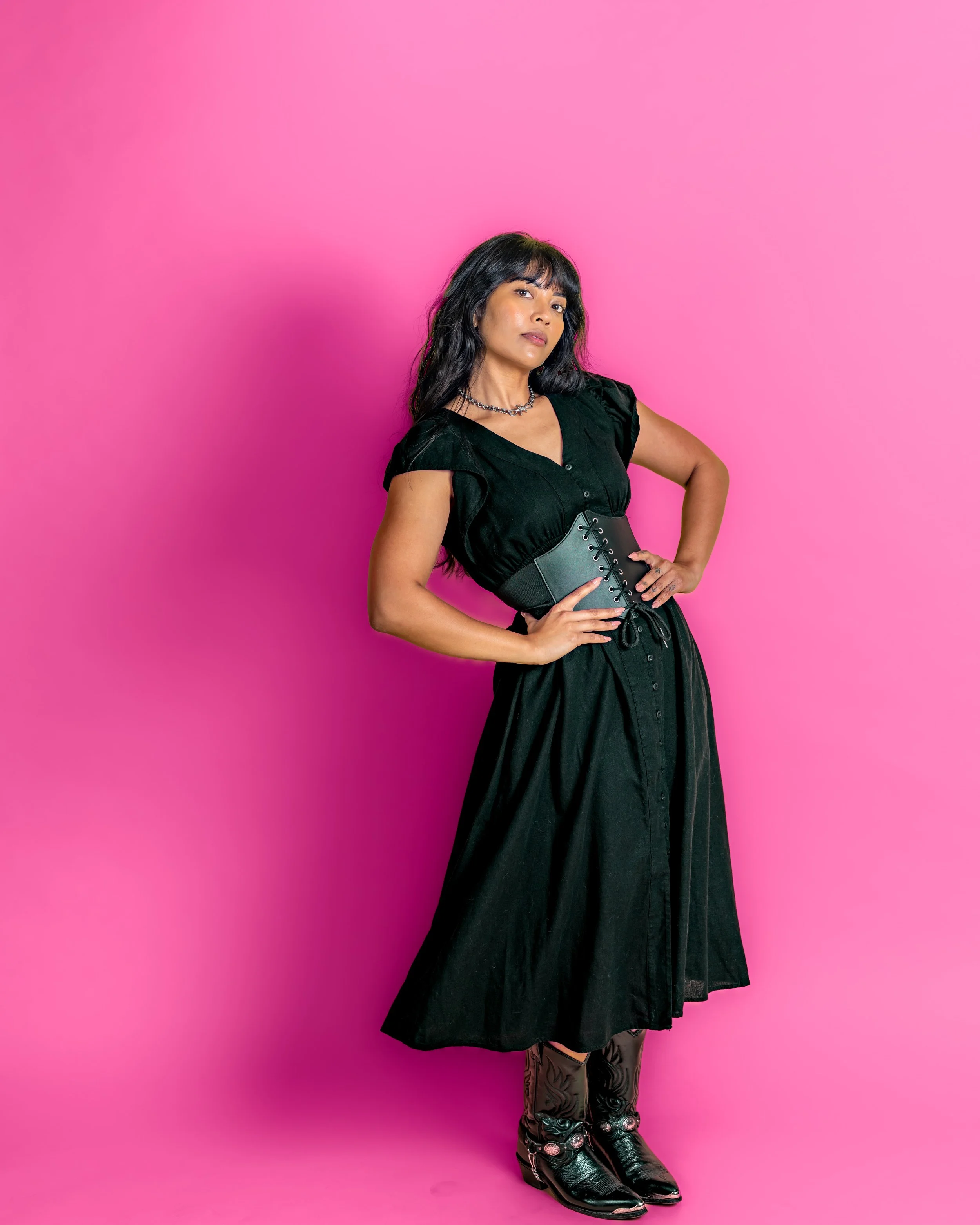 Portrait of a woman wearing all black with with boots and a corset. Portrait was taken in Austin Texas by and Austin Texas photgrapher.