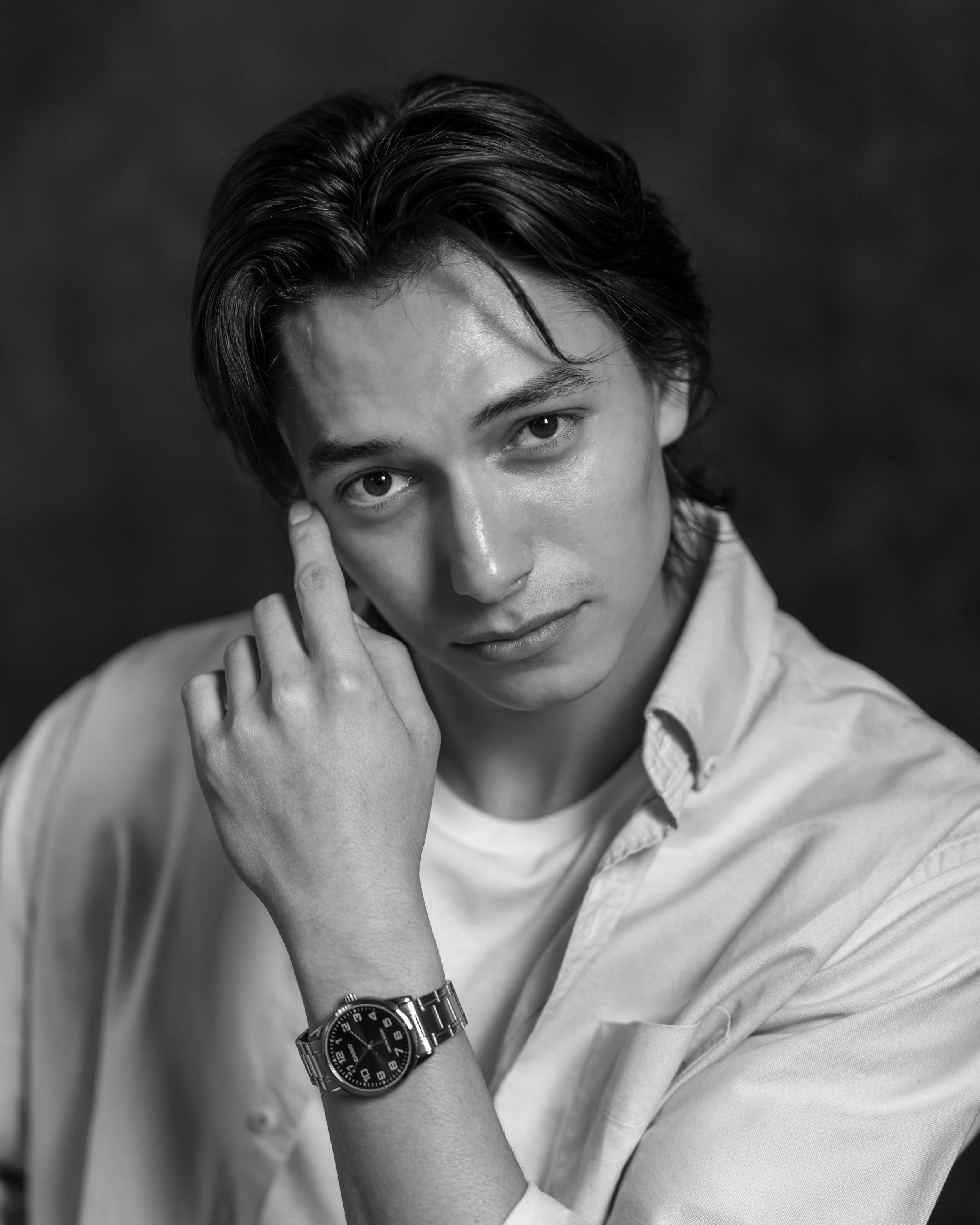 Black and white close-up portrait of a man wearing a watch staring into the lens. Portait taken by an Austin Texas Photographer in Austin Texas.