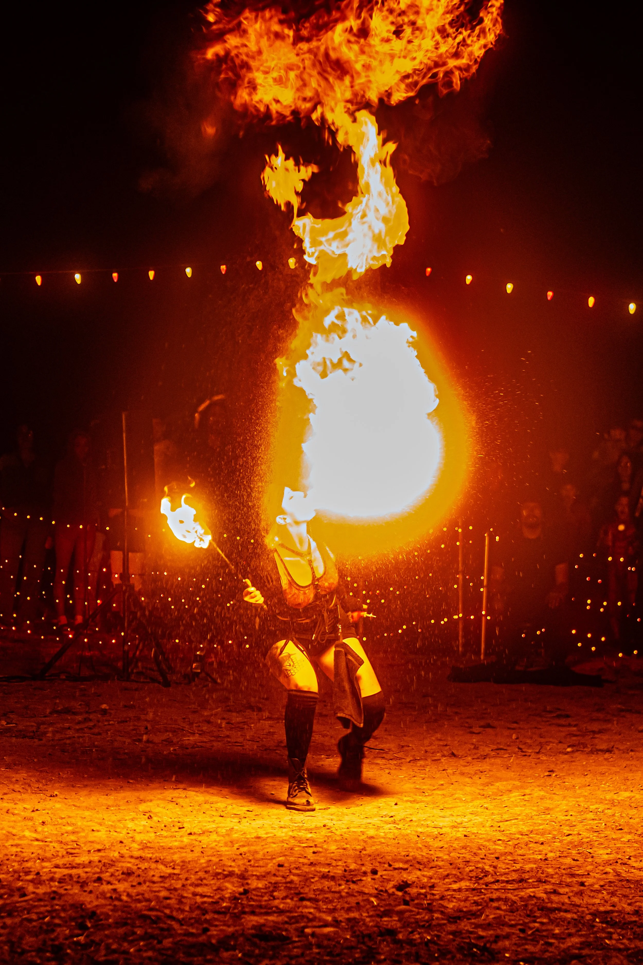 A woman blowing fire into the sky during Halloween at Pumkin Nights in Austin Texas.