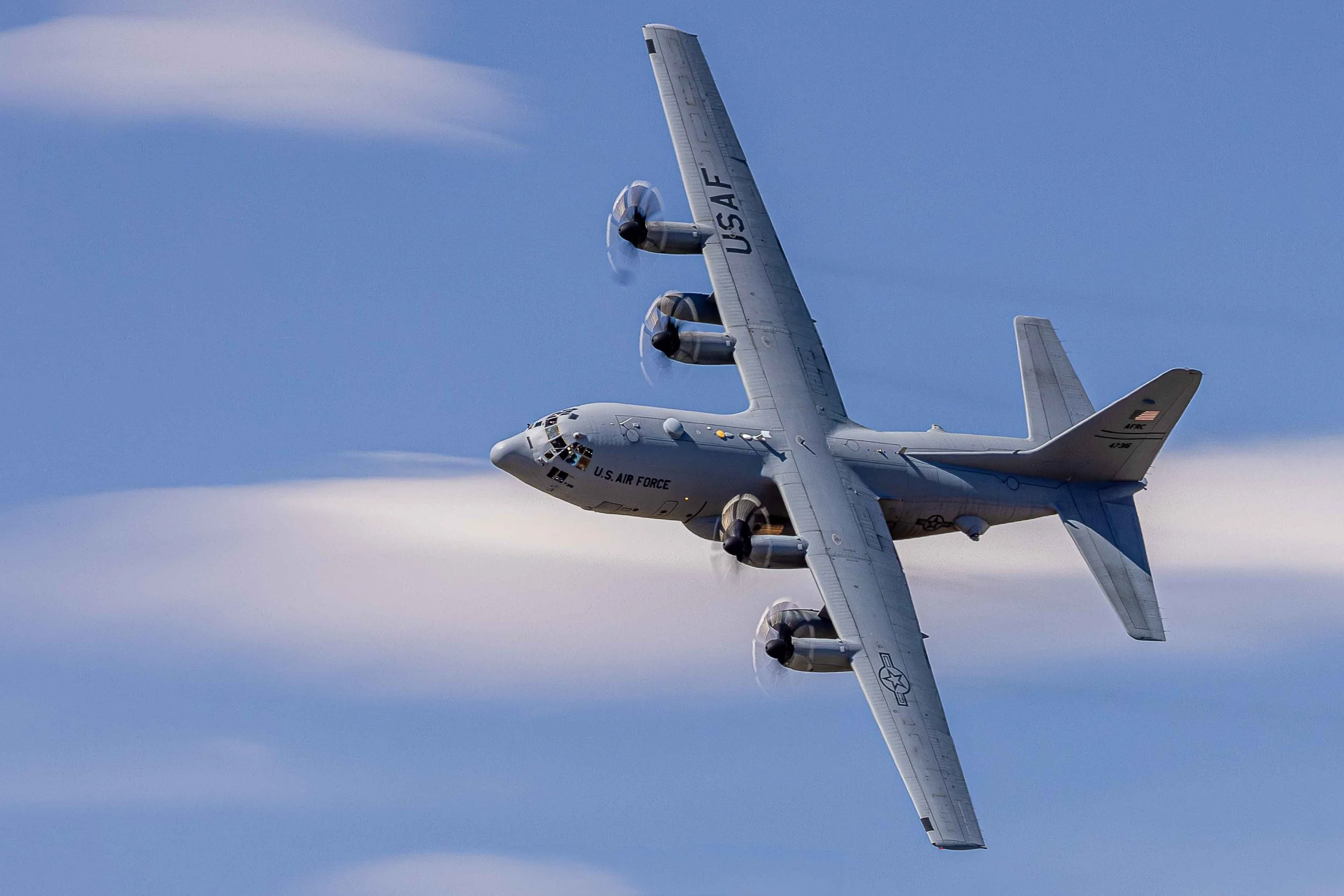 A U.S. Air Force cargo plane flying upside down in the sky.