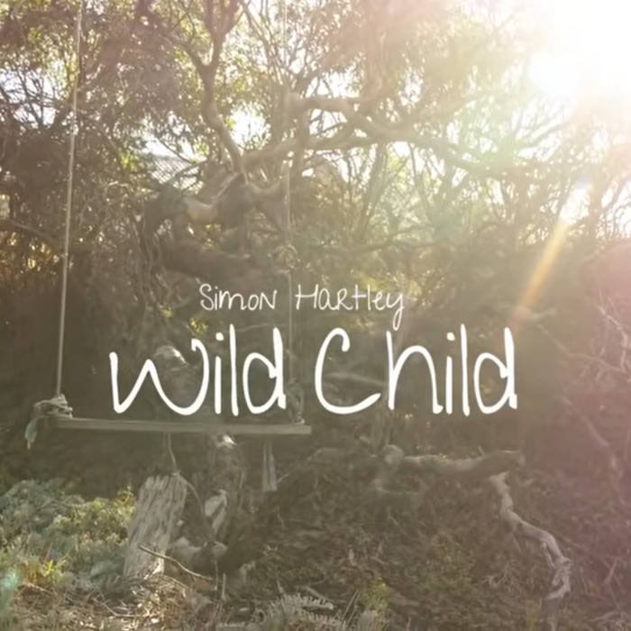 Book cover with a background of trees and sunlight, titled "Wild Child" by Simon Hartley.