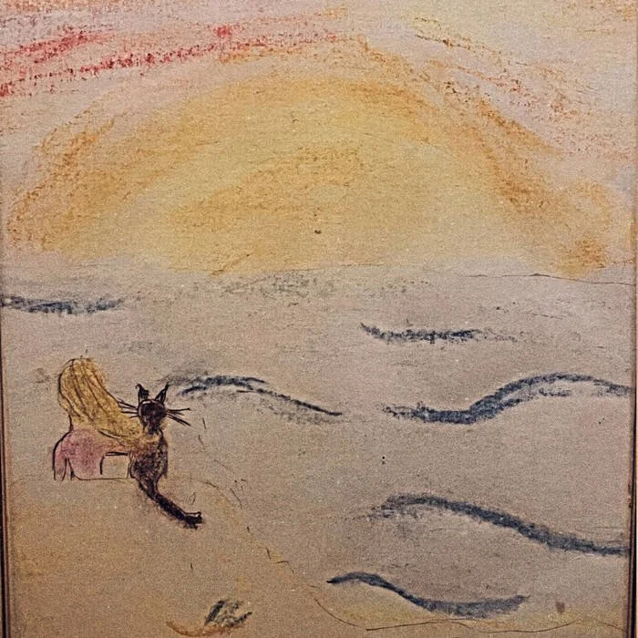 Drawing of a woman with long blond hair sitting on a shore, looking at the ocean during sunset, with a black cat sitting beside her.