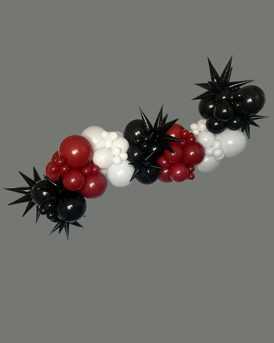 Decorative balloon garland with black, white, and red balloons against a gray background.