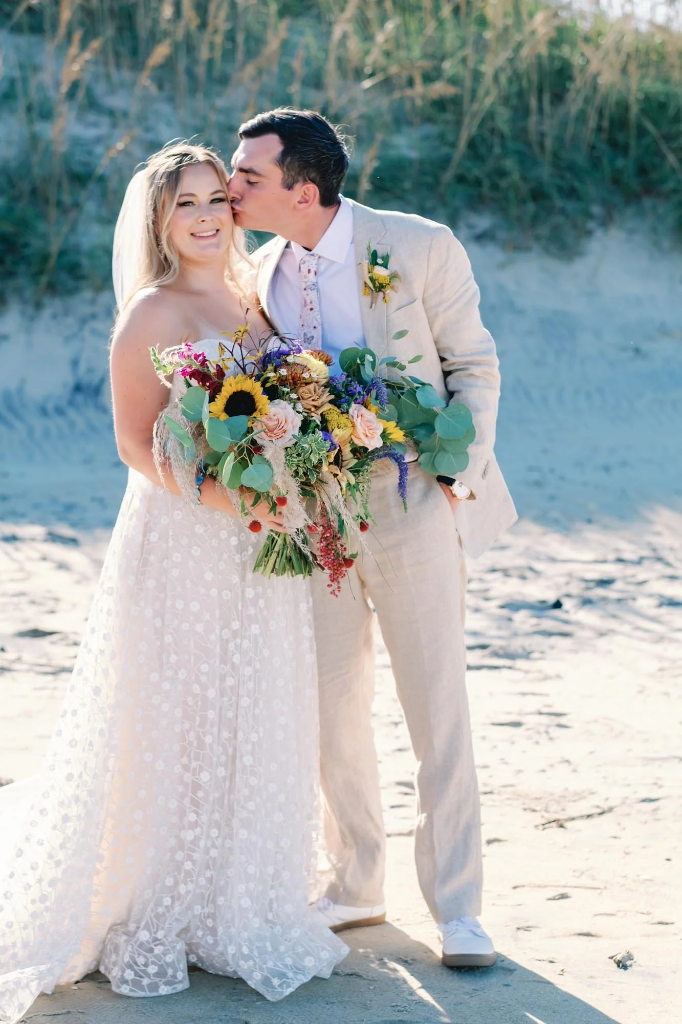 Outer Banks wedding couple on beach holding large whimsical bouquet for preservation by Beaux’s Botanicals