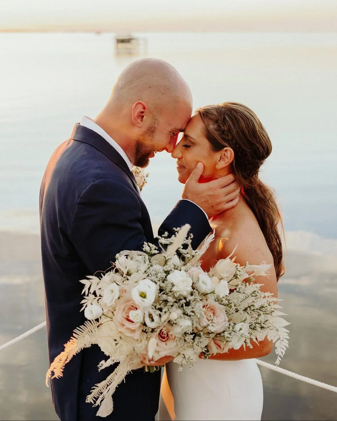 Wedding couple holding a modern floral bouquet later preserved by Beaux’s Botanical Preservation in the Outer Banks