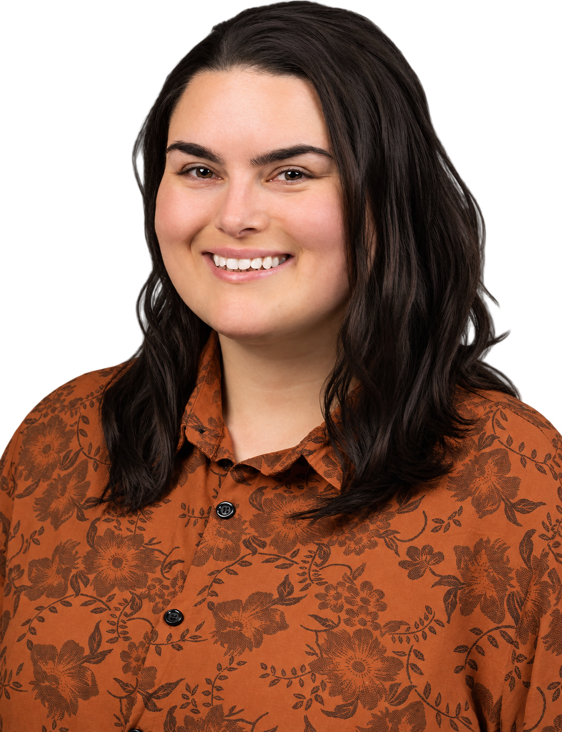 Close-up of Dr. Thomas: a woman with dark brown hair, smiling, wearing a rust-colored blouse with a floral pattern.