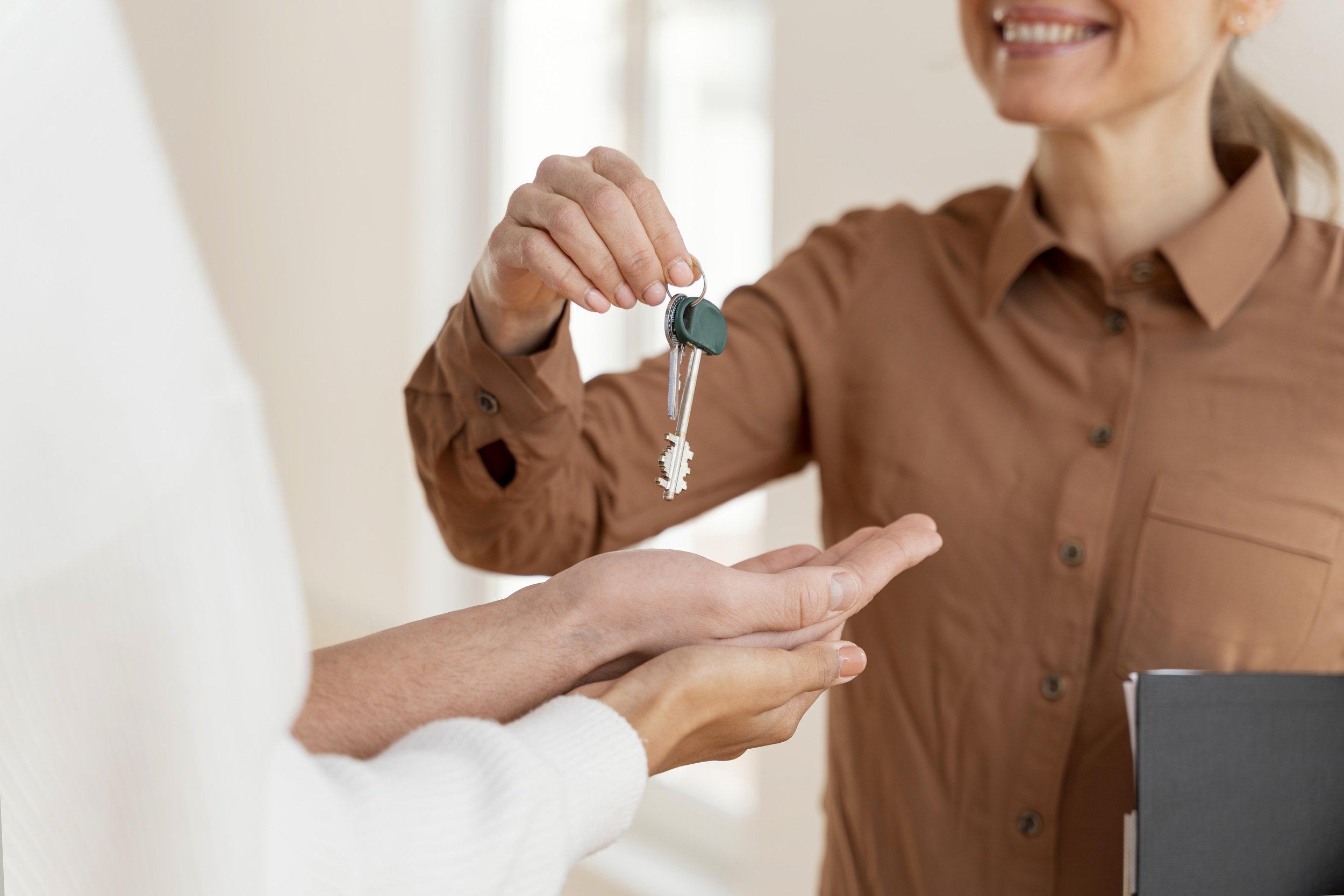smiley-female-realtor-handing-couple-keys-their-new-home.jpg