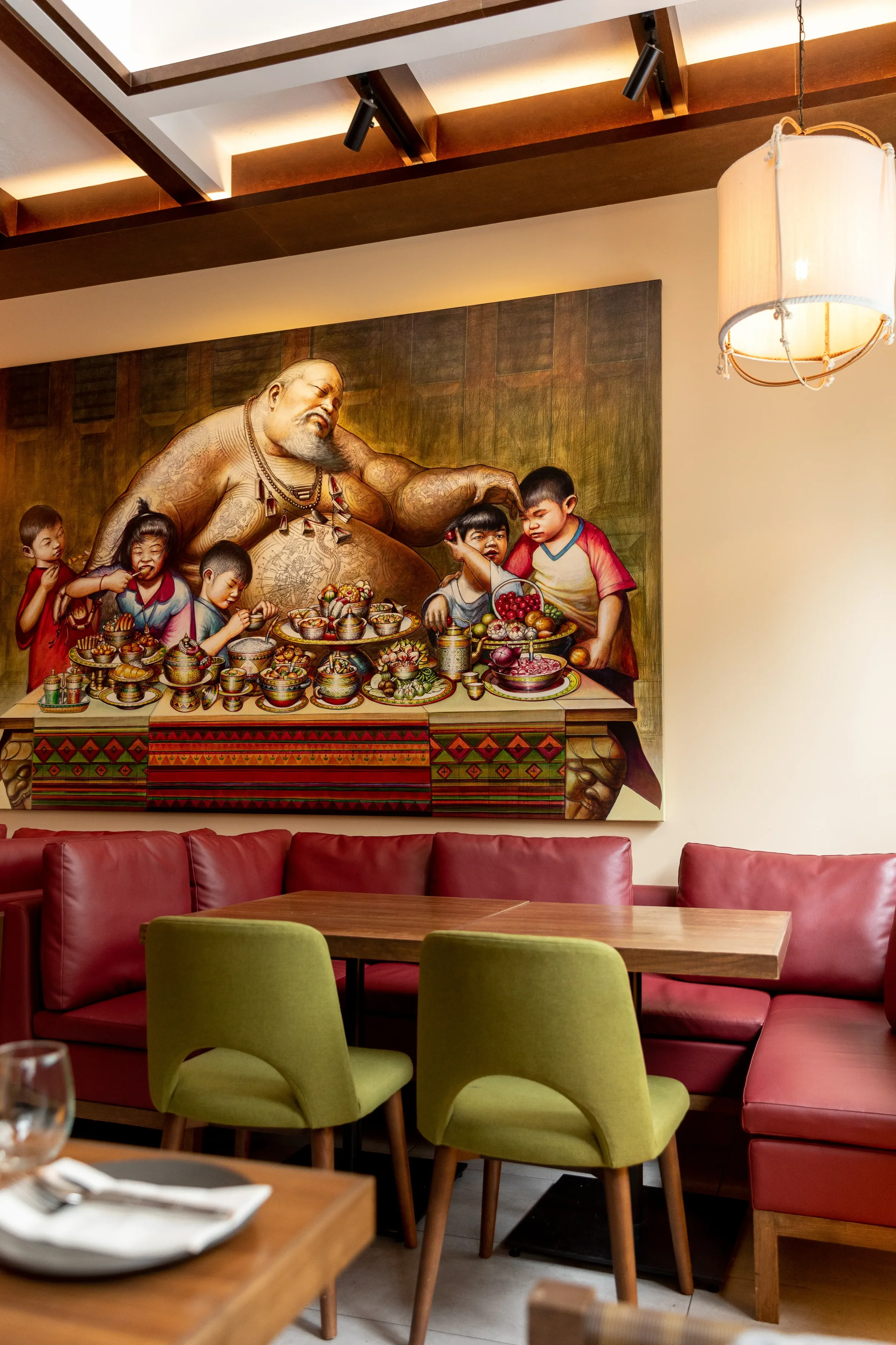 photo of jumbo thai's main group dining room with chairs and tables and a big wall Thai painting
