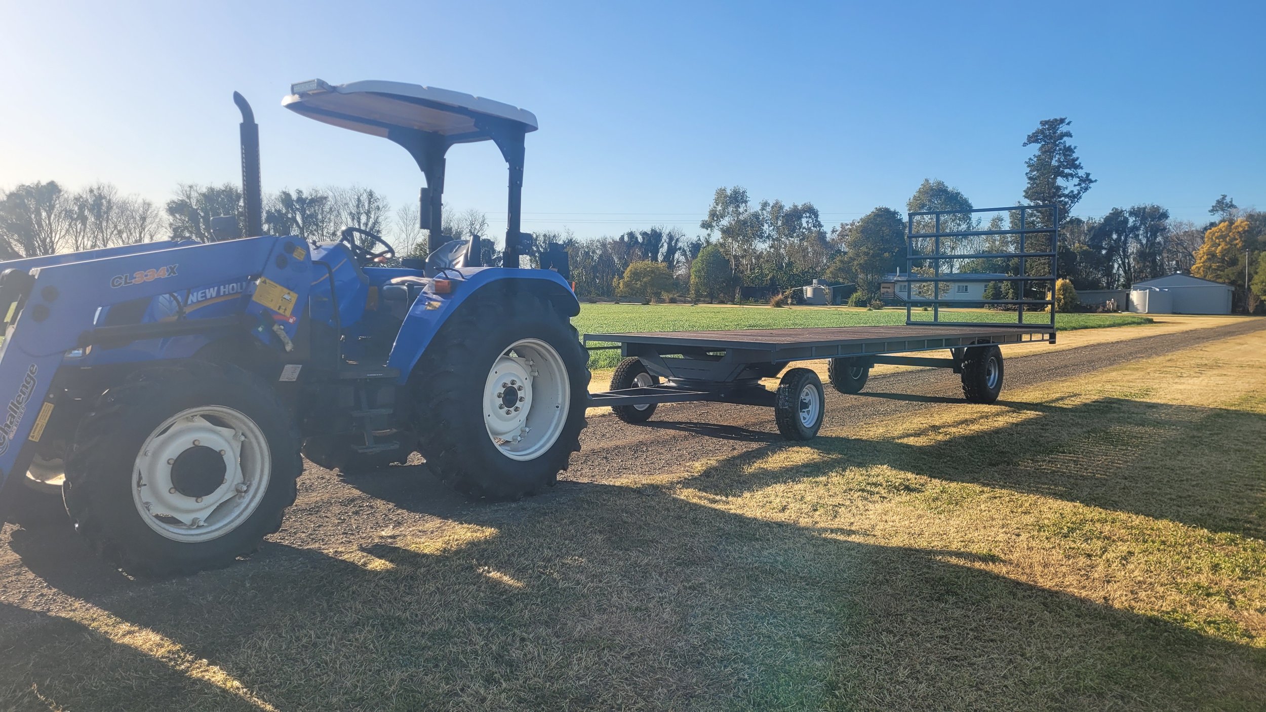 Muller Fabrications hay trailer behind a blue New Holland tractor