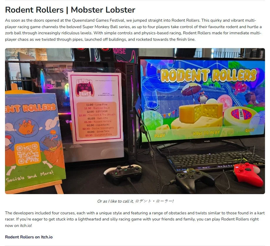 Video game setup with a screen displaying the game 'Rodent Rollers', a keyboard, two gaming controllers, and promotional signage, at the Queensland Games Festival.