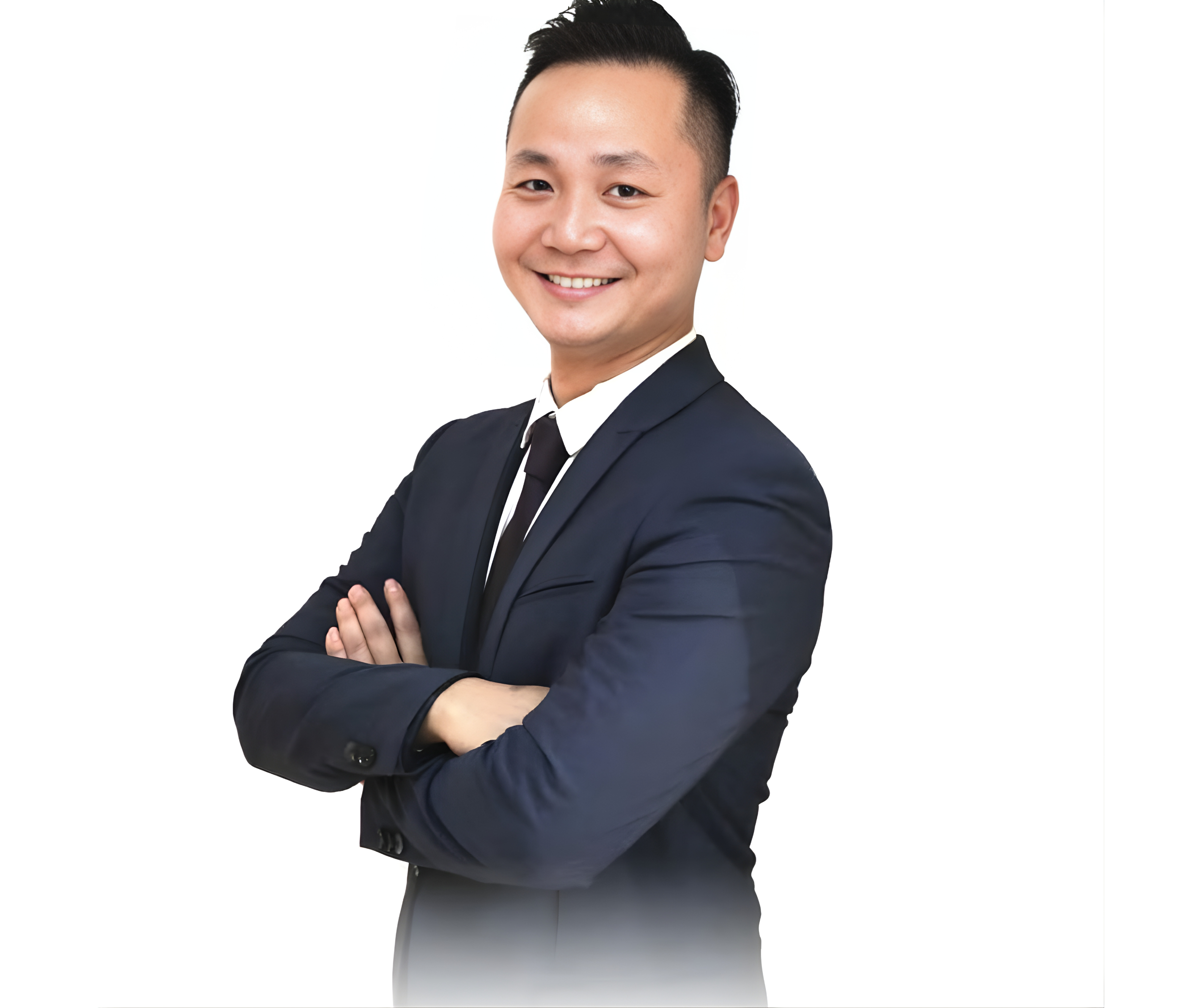 Portrait of a smiling man in a navy blue suit with arms crossed, against a white background.