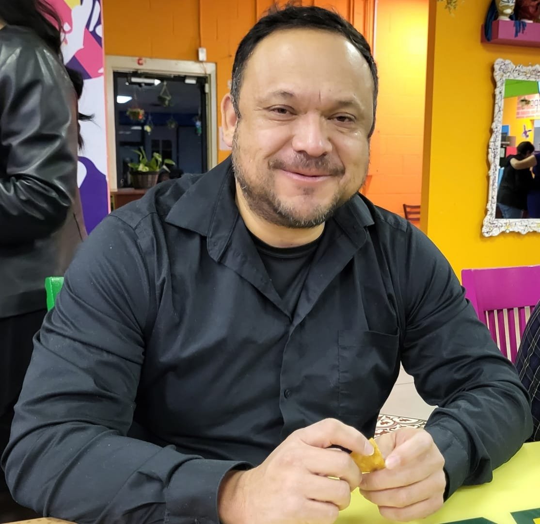 Ruben Rios, a Republican candidate for US Congress in Texas District 16 smiling and sitting at a colorful restaurant table.