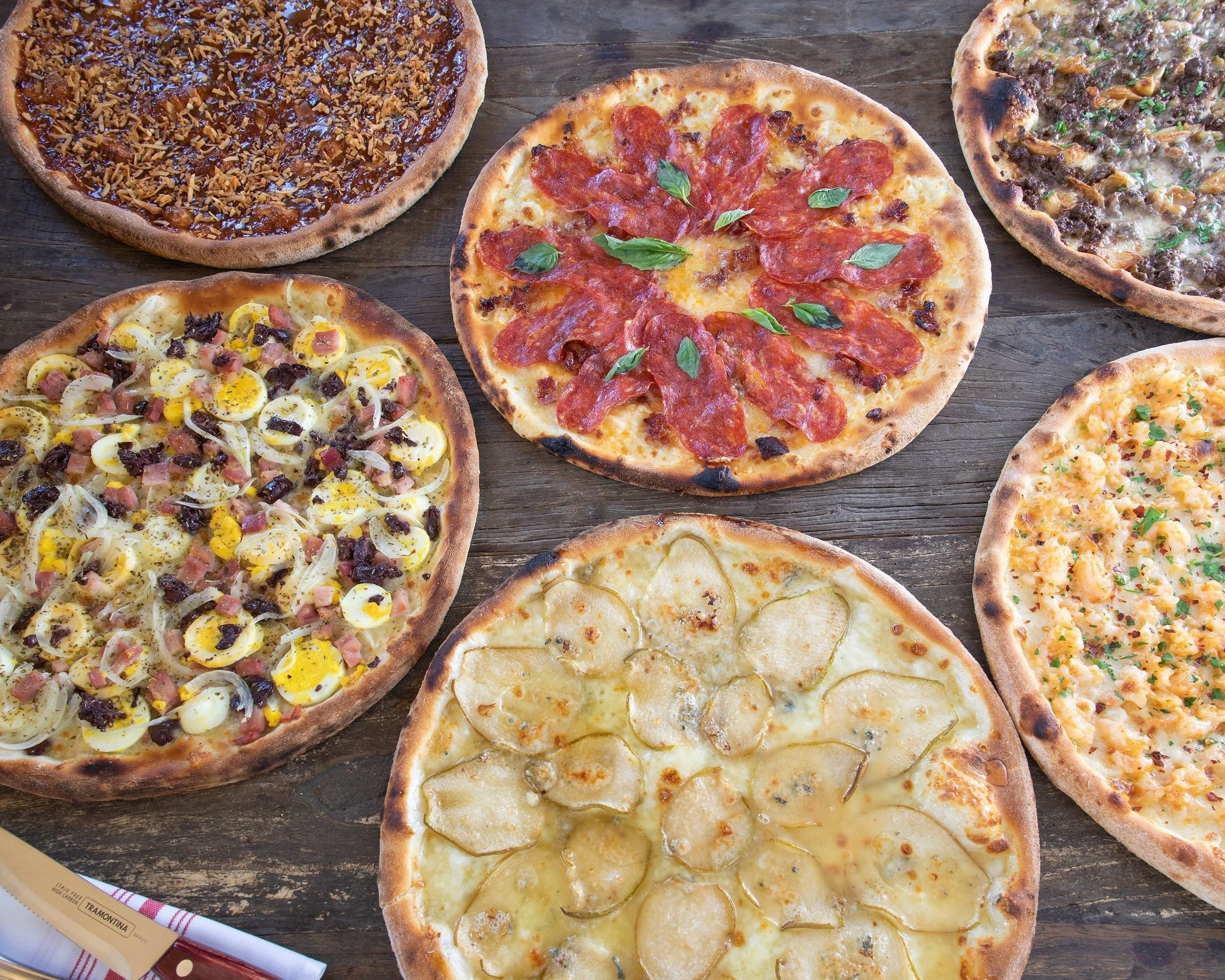 Assorted wood-fired pizzas at Delucca Gaucho Pizza & Wine in Plano, Texas.