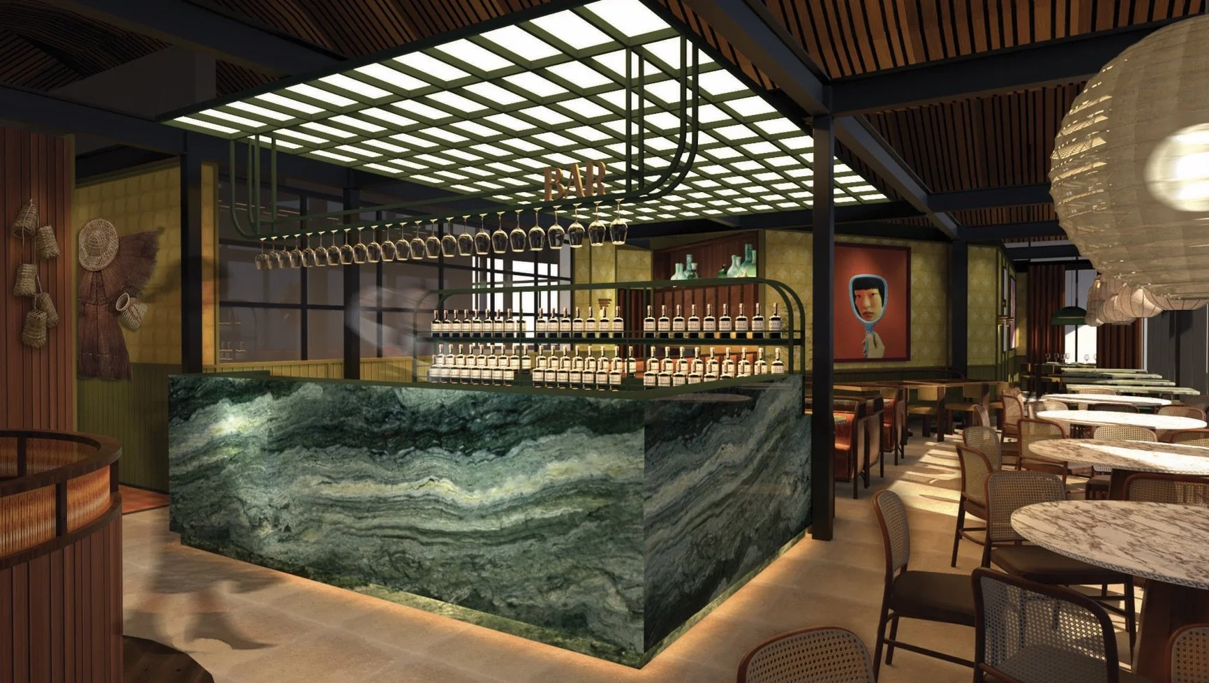 Interior of a stylish restaurant with a bar made of green marble, hanging wine glasses, and bottles on shelves. There are round marble tables with wicker chairs, artwork on the walls, and soft ambient lighting.