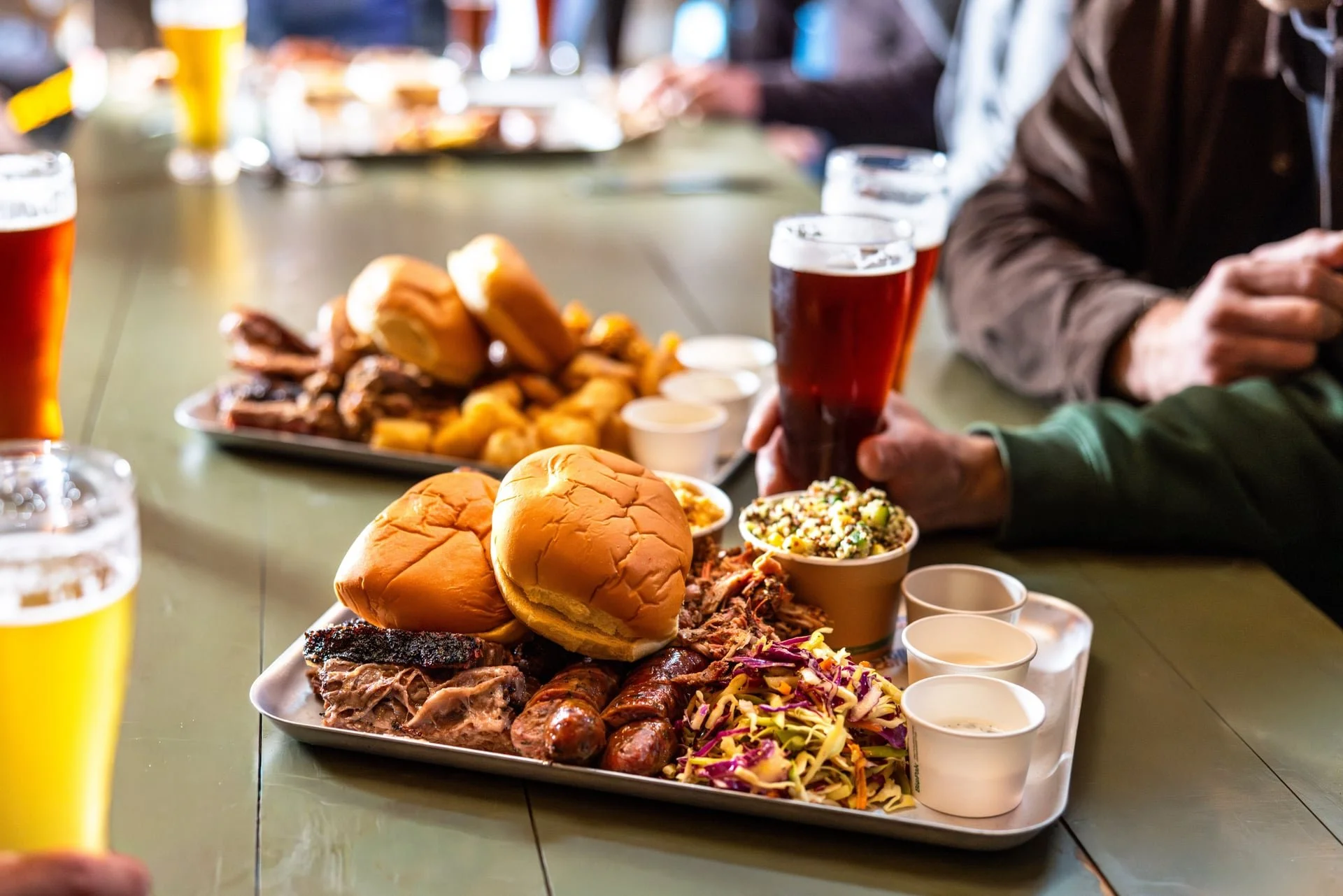 Texas Style BBQ platter at Old Mill Brewery featuring authentic American-style barbecue in Tanunda with smoked brisket, sausage, buns, coleslaw and southern sides, served alongside craft beer in the heart of the Barossa Valley.