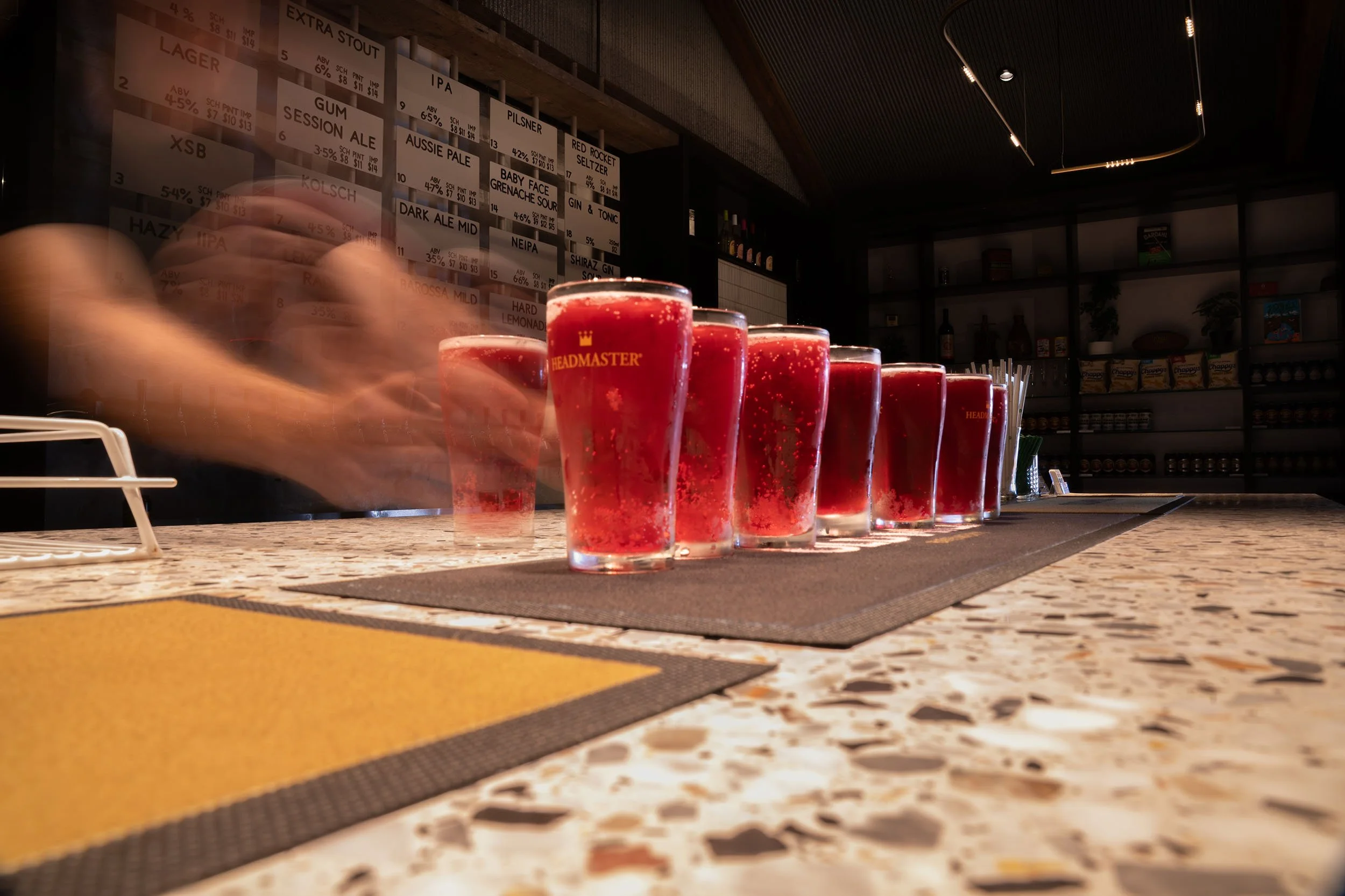 Craft beer tasting paddle being served at Old Mill Brewery in Tanunda, Barossa Valley with bar taps and drinks menu in background.