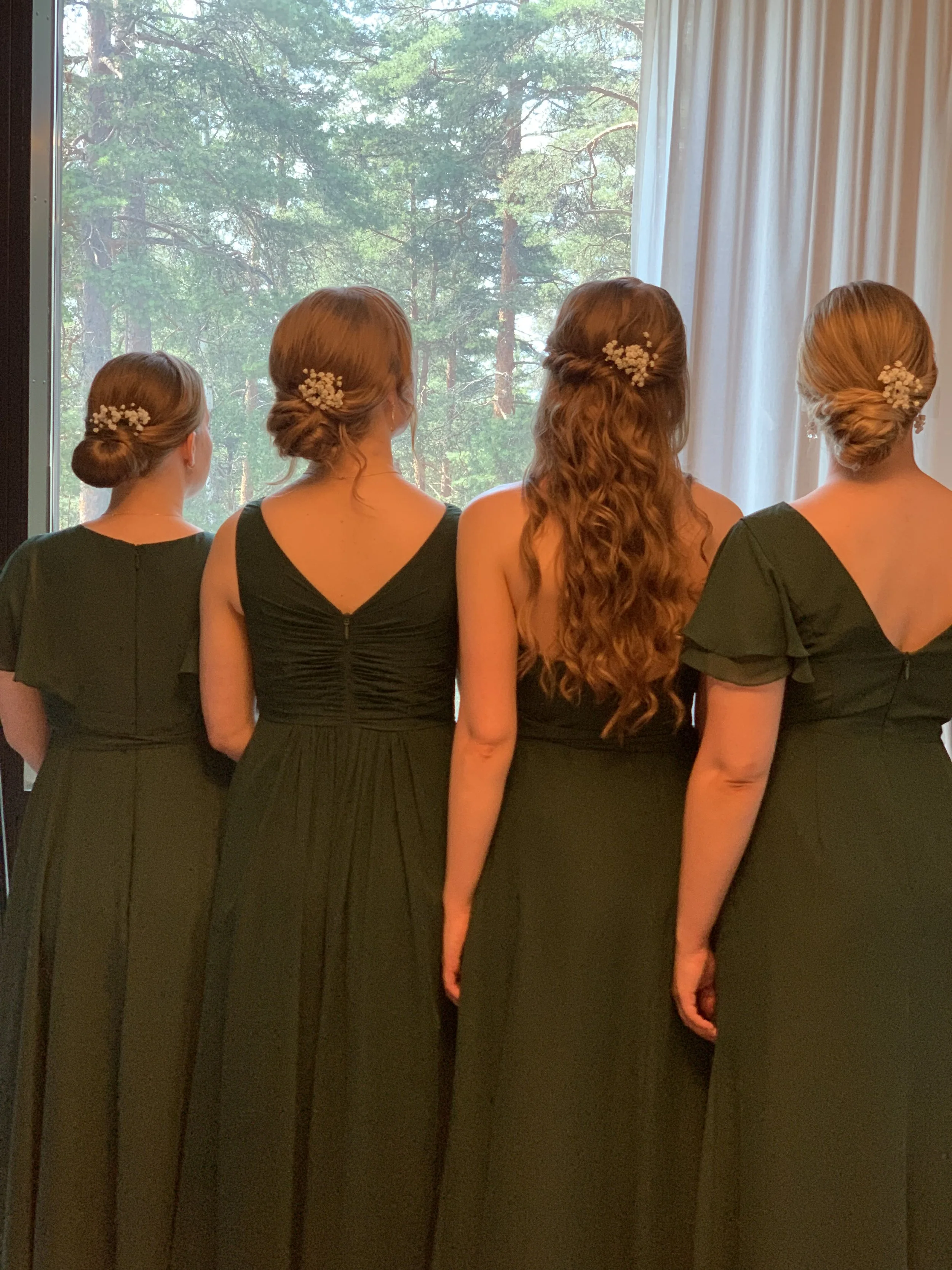 Hääseurueen jolla vihreät mekot,  näyttävät, mutta edulliset kampaukset kuvattuna takaapäin