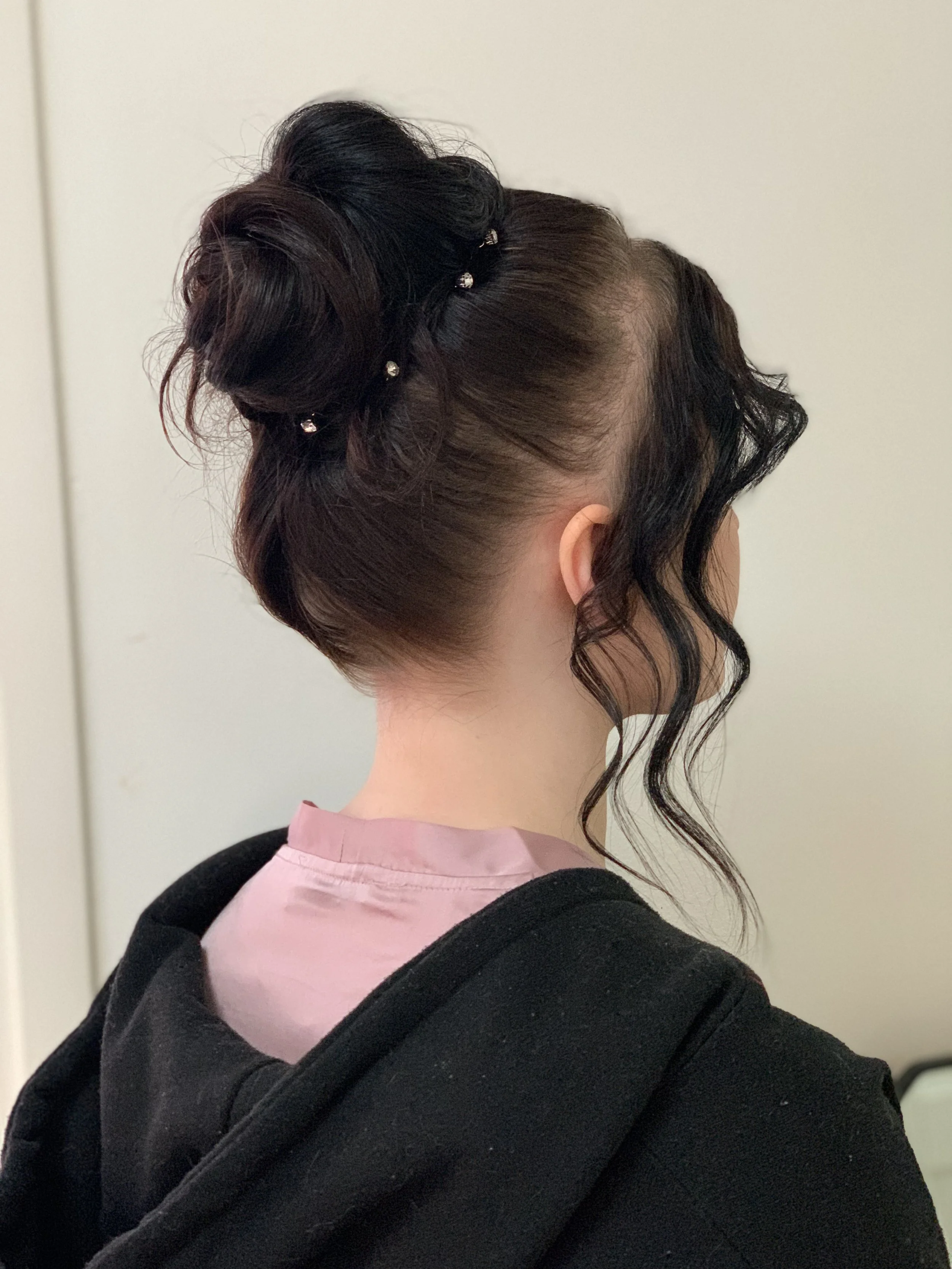 Juhlakampaus / nuttura tummissa hiuksissa takaapäin kuvattuna