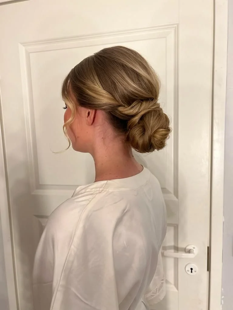 Hääkampaus vaaleahiuksisella naisella kuvattuna takaapäin