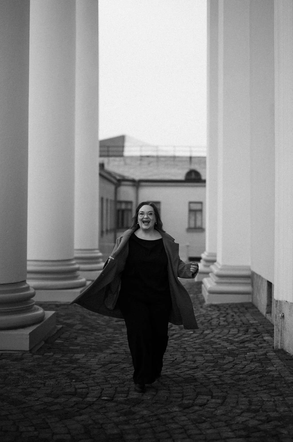 Mustavalkoinen kuva jossa Sonja, meikkaaja-kampaaja pääkaupunkiseudulta, kävelee iloisena Helsingissä