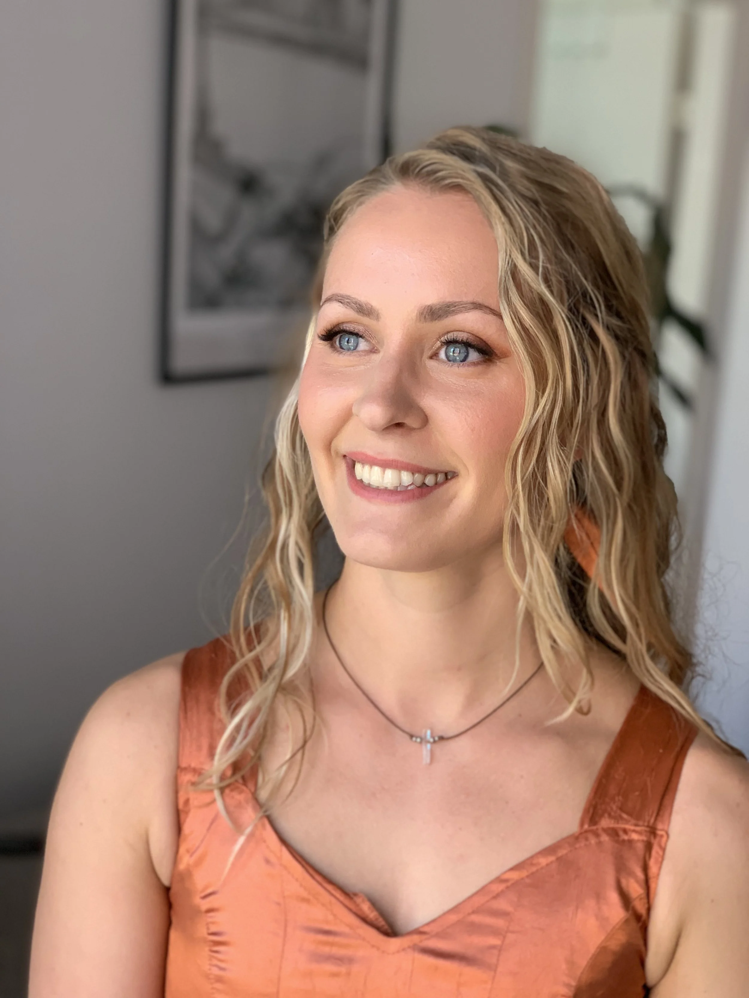 Luonnollinen juhlameikki vaaleahiuksisella naisella joka hymyilee