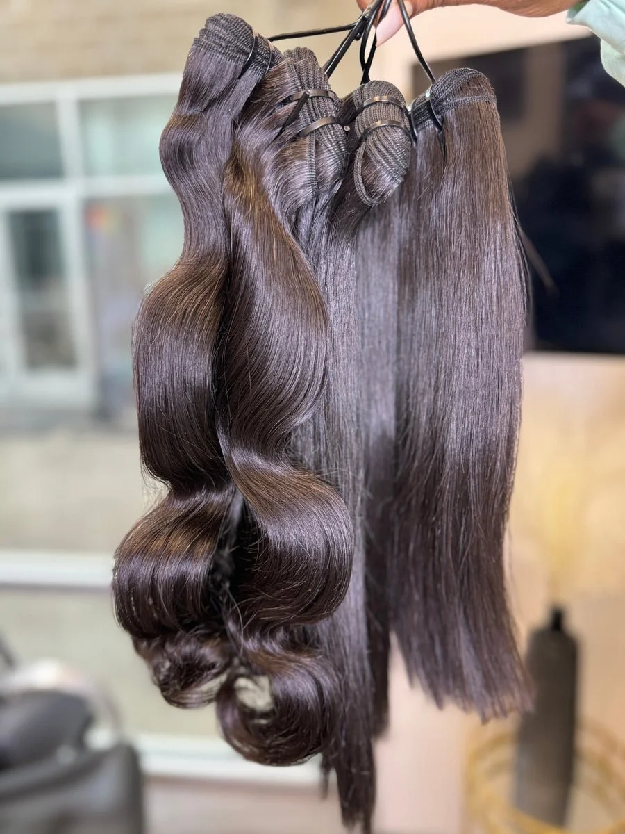 Virgin hair bundles held up together, one wavy and one straight, showing natural shine and fullness
