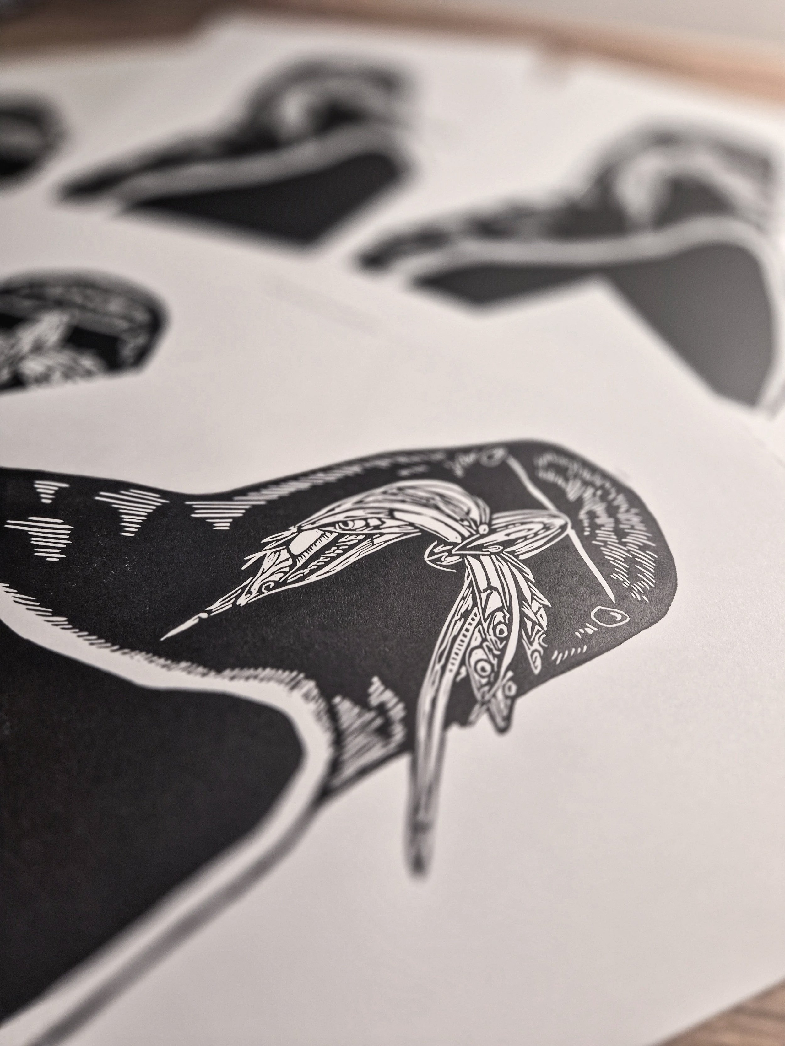 Impression d'art linogravure en noir et blanc d'un pingouin torda tenant dans son bec un bouquet de sardines