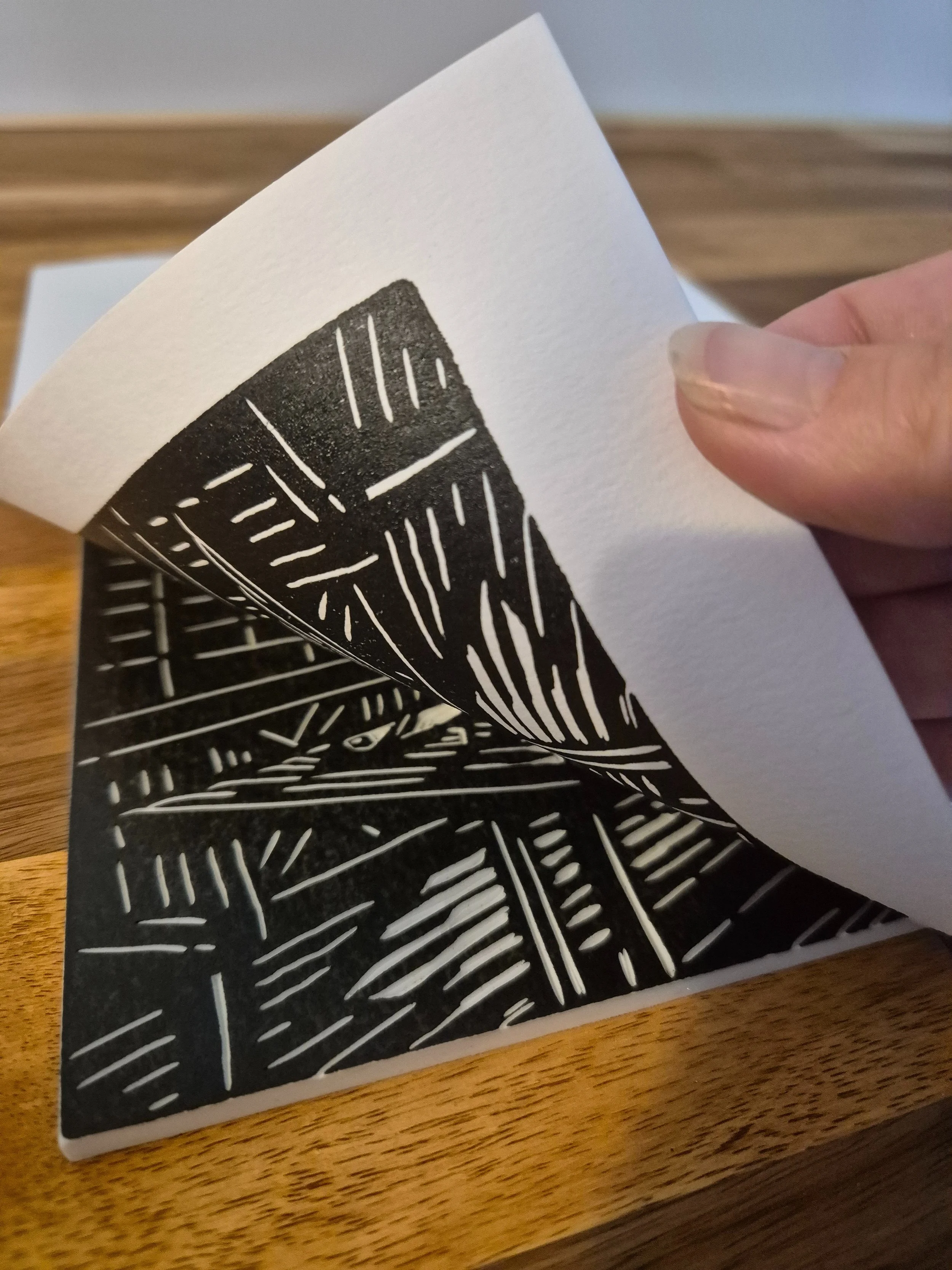 Estampe « Caffè all’Angolo » roulée dans la main, montrant le papier de qualité utilisé pour cette linogravure faite main, prête à être expédiée en toute sécurité.