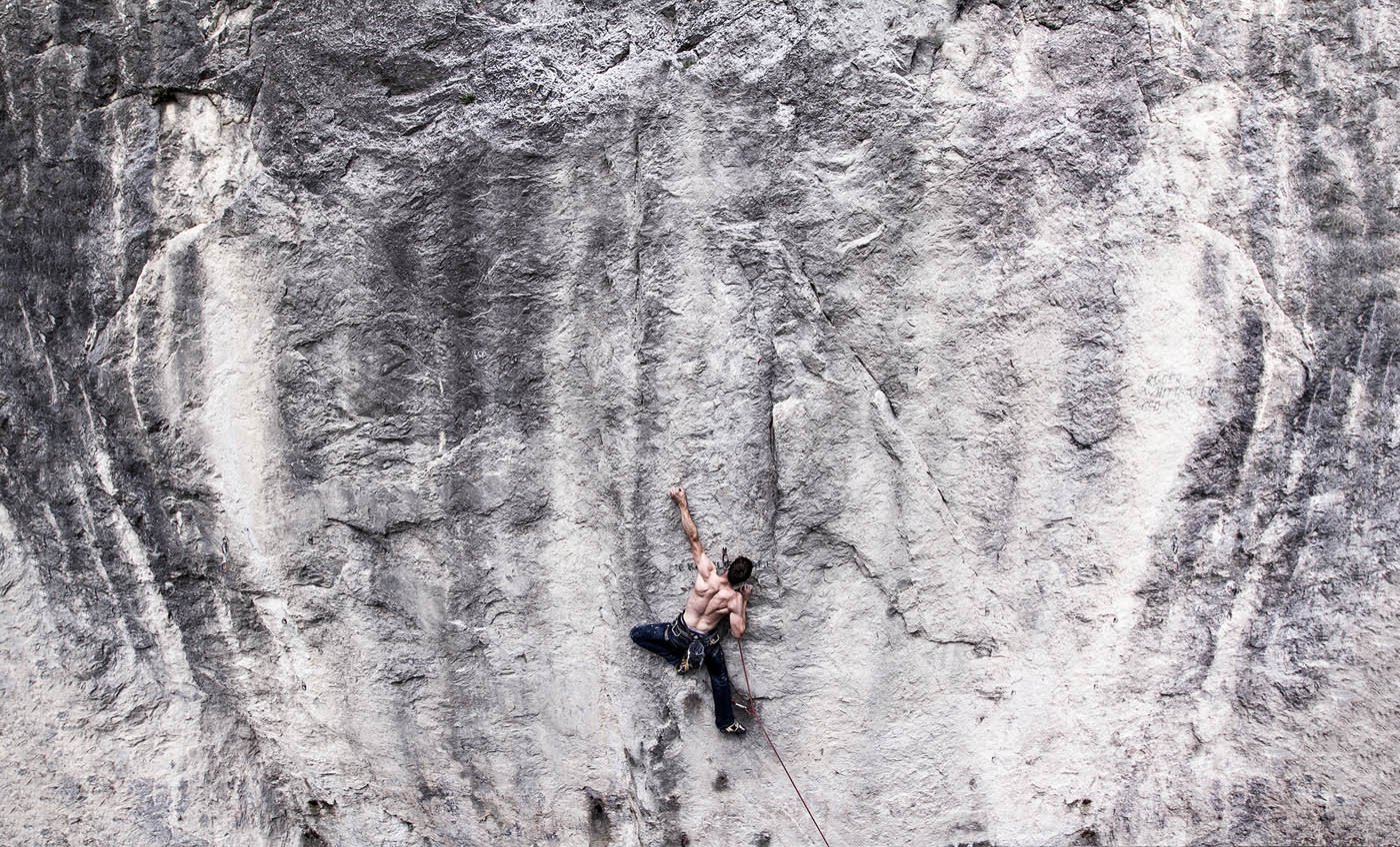 Kletterer an einer steilen, felsigen Wand, ohne Seil