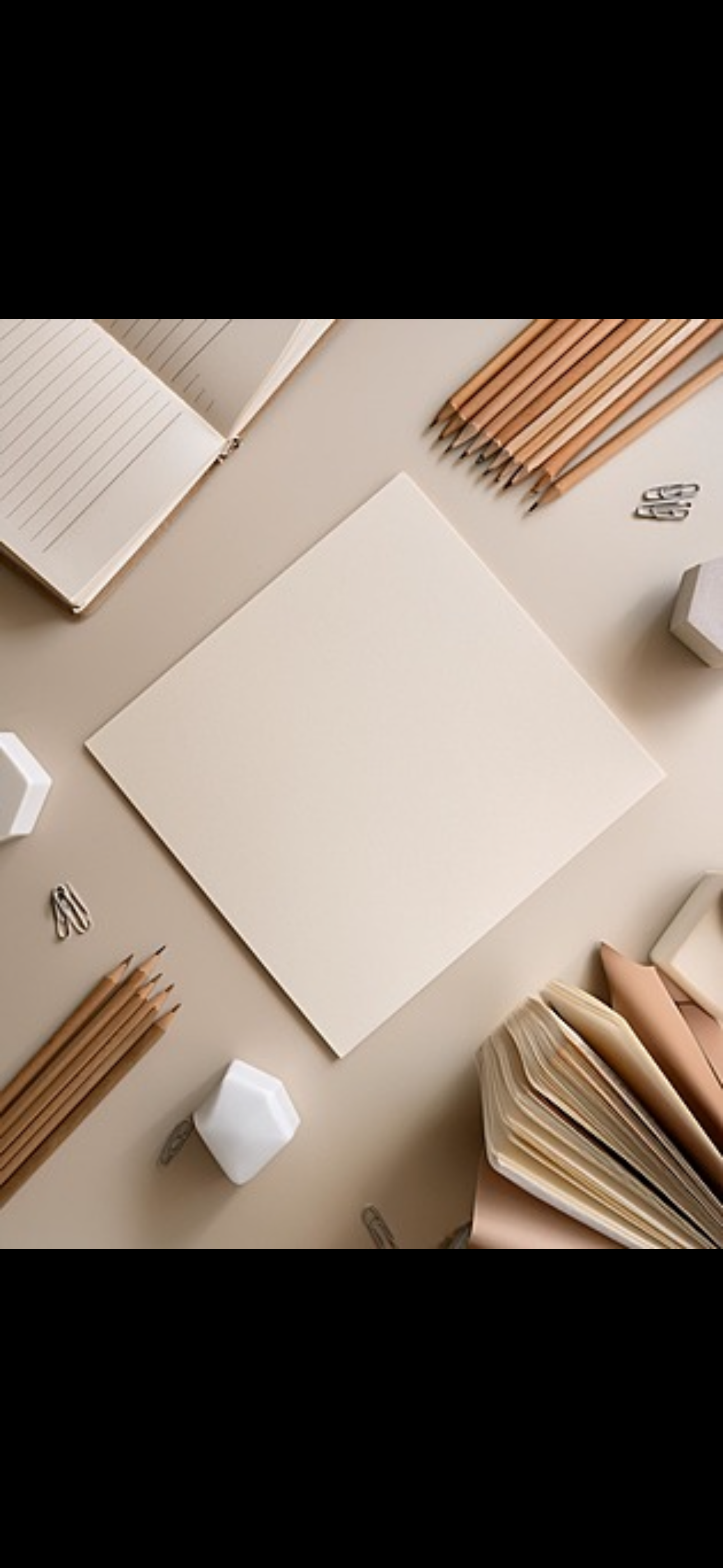 A flat lay of minimalist stationery on a beige background, including an open notebook, a blank square card, several colored pencils, paper clips, a hexagonal white container, and a stack of paper or notebooks.