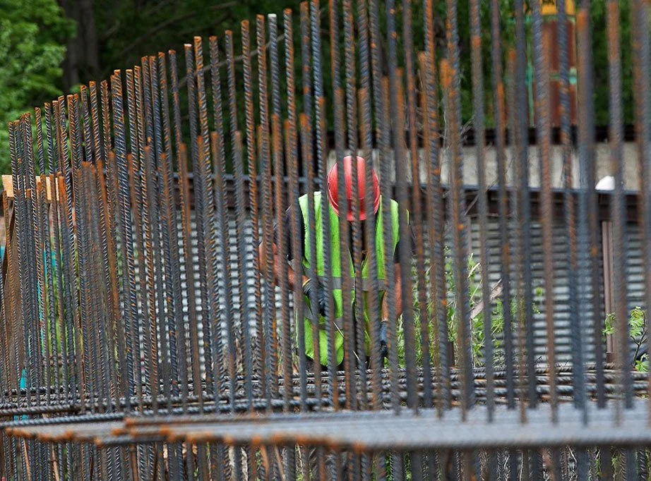 Treballador de COPSA amb casc i armilla de protecció que analitza una estructura de ferro en una obra.